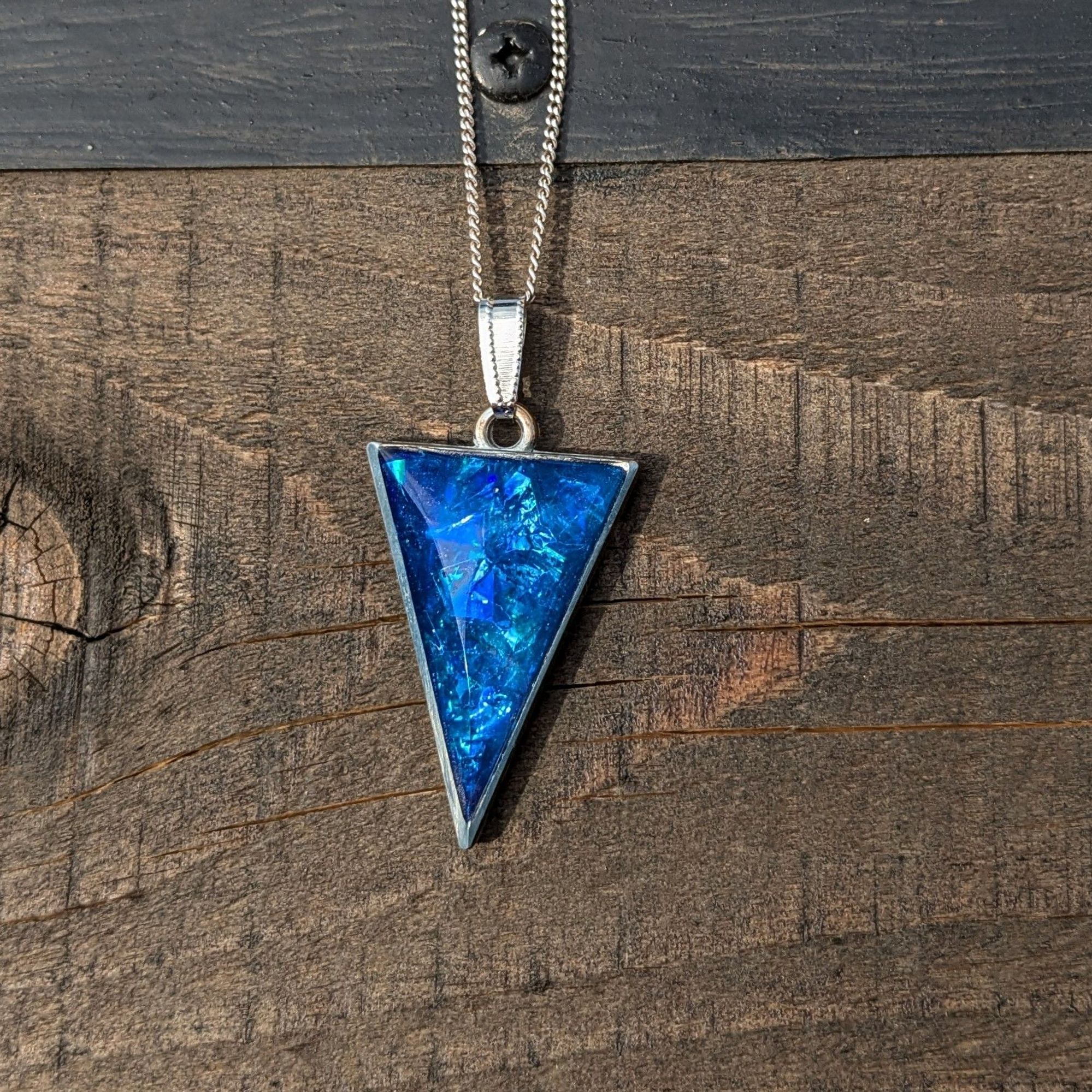 Pendentif triangulaire cerclage métallique et cristal en résine dichroïque