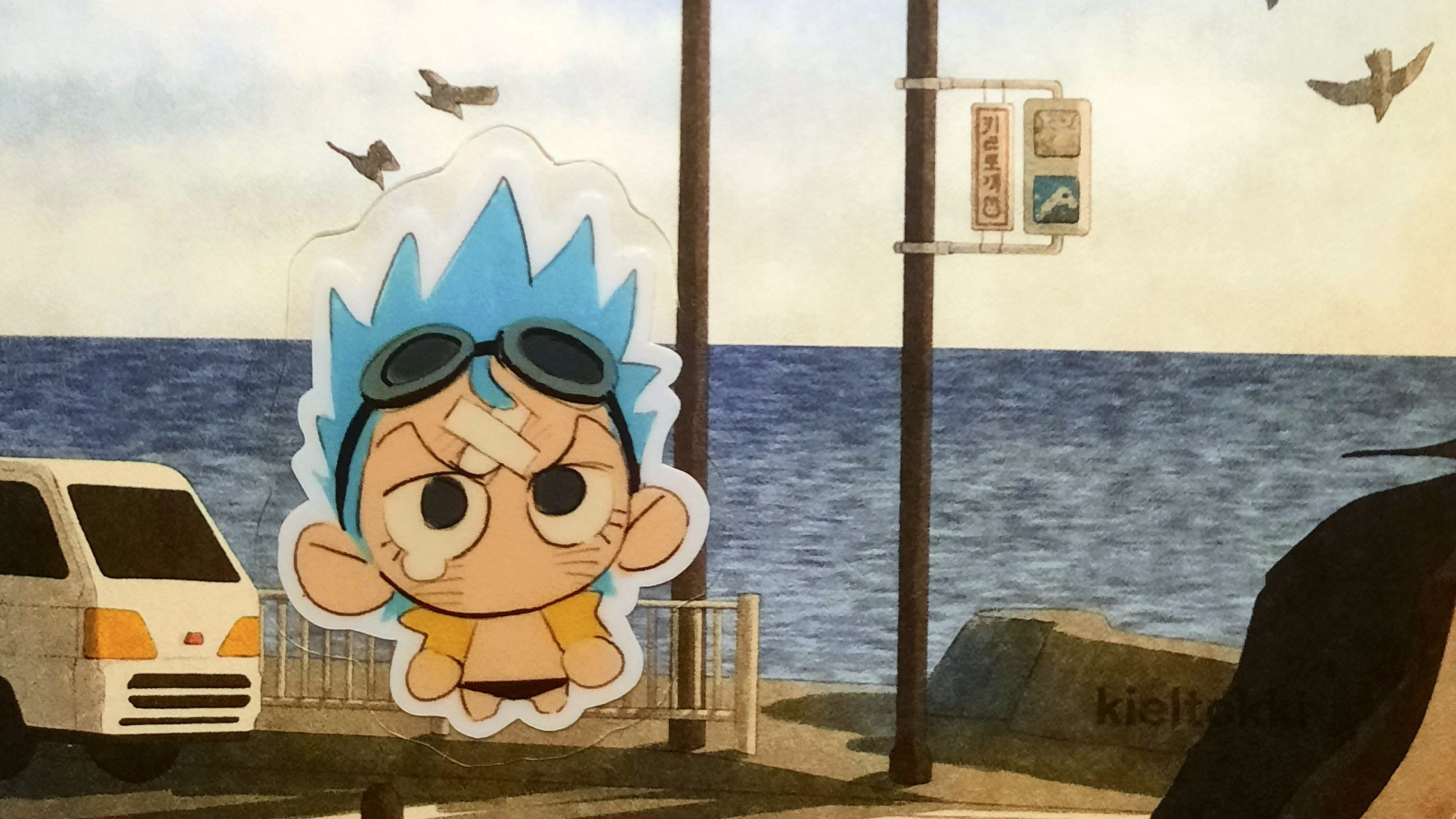 one piece: a sticker of franky, small and teary-eyed, against a backdrop of a printed drawing of the seaside