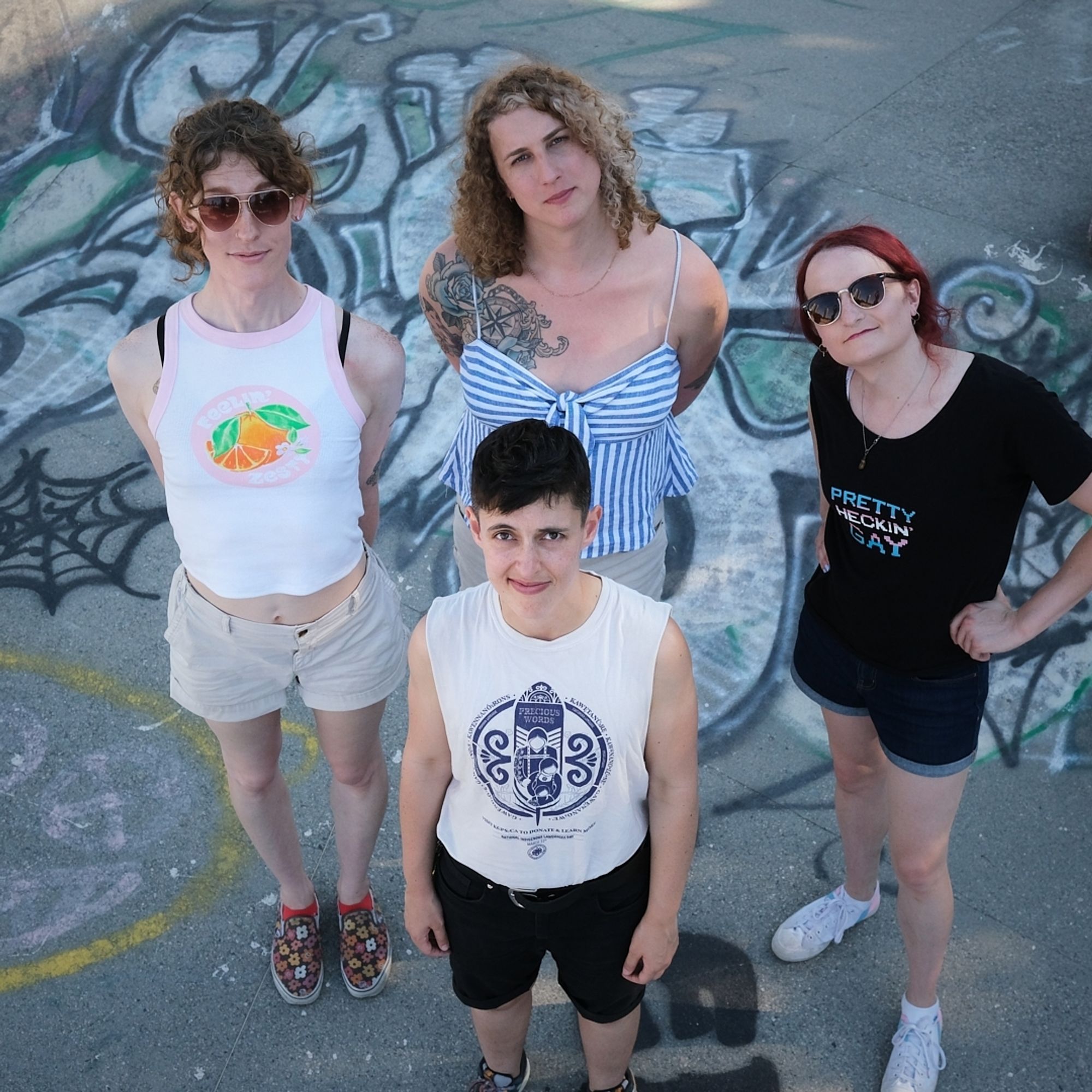 the band, looking up at the camera in a skatepark