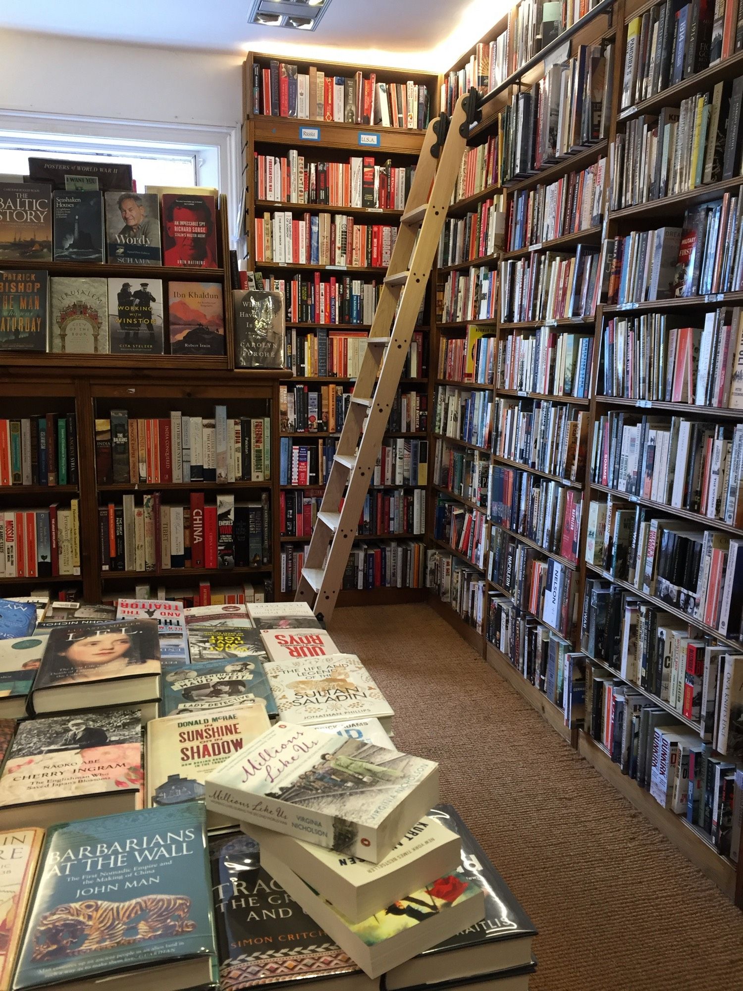 A photograph inside a bookshop. Two walls of floor to ceiling books are visible, in the far corner a ladder is placed for east of browsing. A table is also liberally covered with books.
For the curious, this photograph was taken inside Toppings Bookshop in Ely, some years ago.