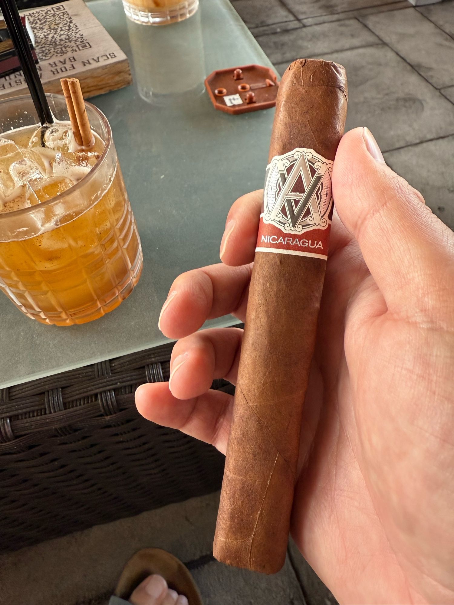 Cigar and mixed drink in frame.