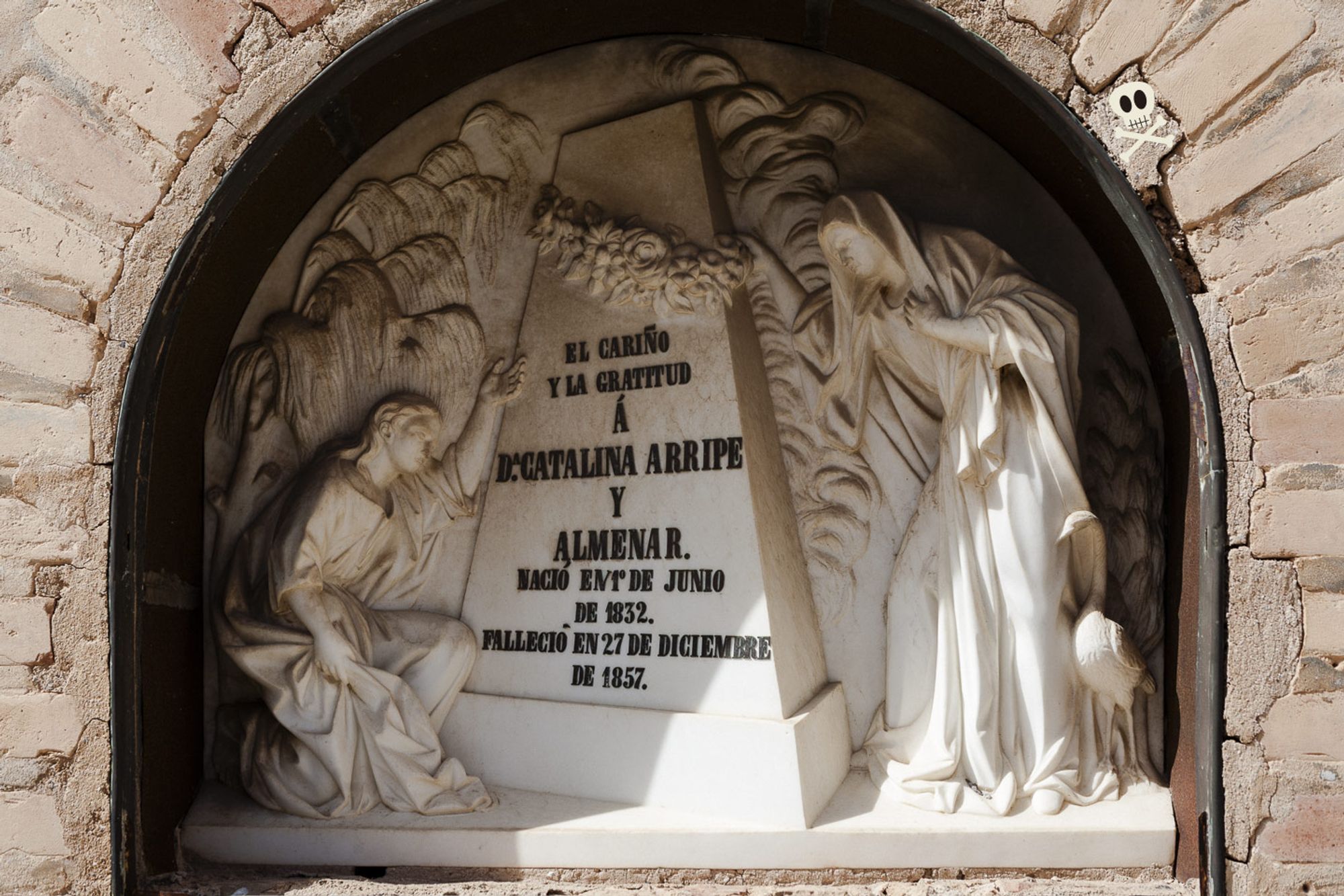 Nicho de Catalina Arripe Almenar, de mármol blanco, con dos dolientes (hombre y mujer vestidos a la romana) colocados a sendos lados de una pirámide  u obelisco truncados. Al lado de la mujer un pájaro —posiblemente una garza o una grulla; aunque pudiera ser ¿un ibis?— y al fondo, fronda con sauce, ciprés y otros elementos menos reconocibles. Chulísima, vaya.