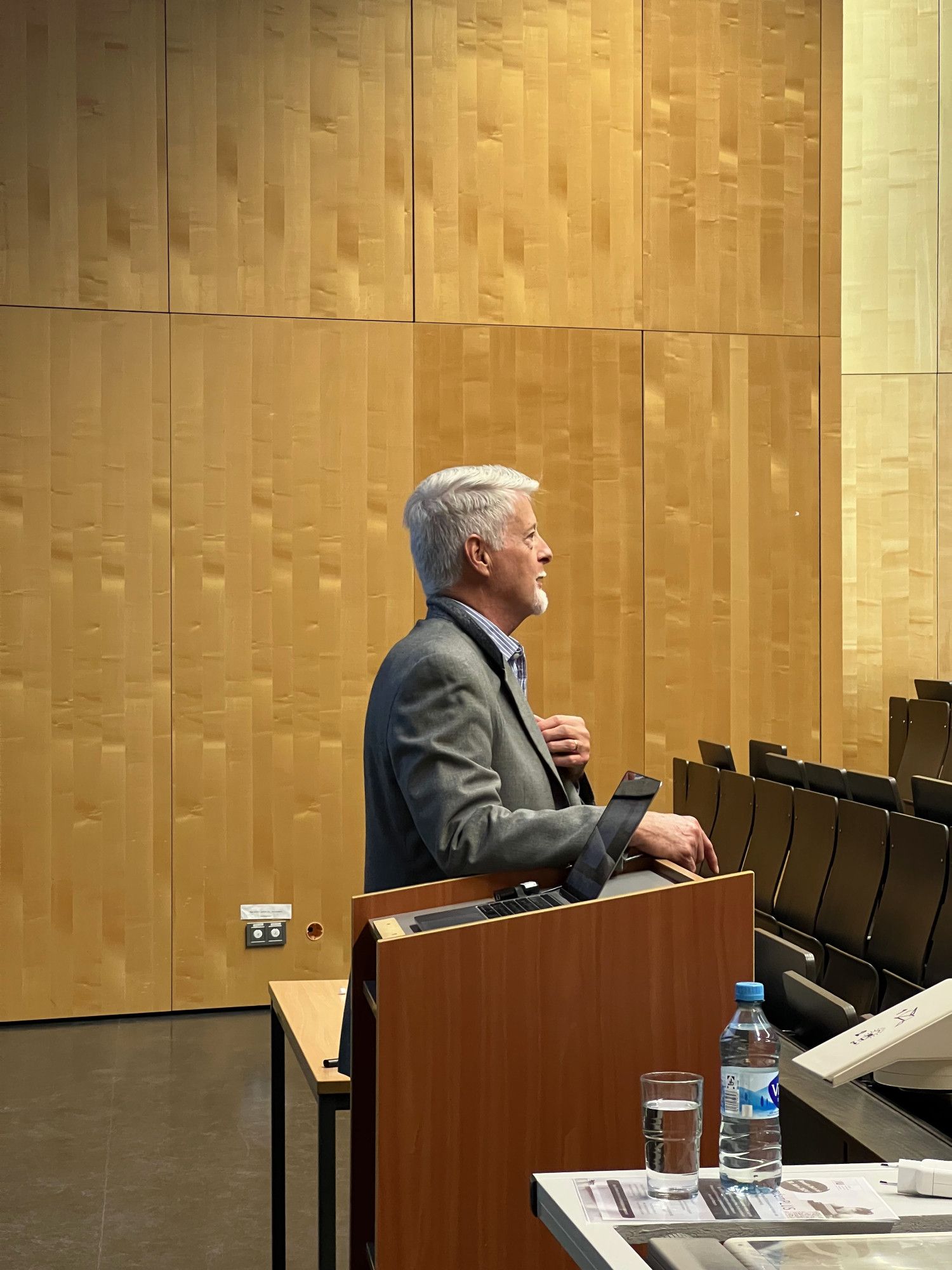 Prof. Ronald Rice steht in einem Hörsaal der LMU München.