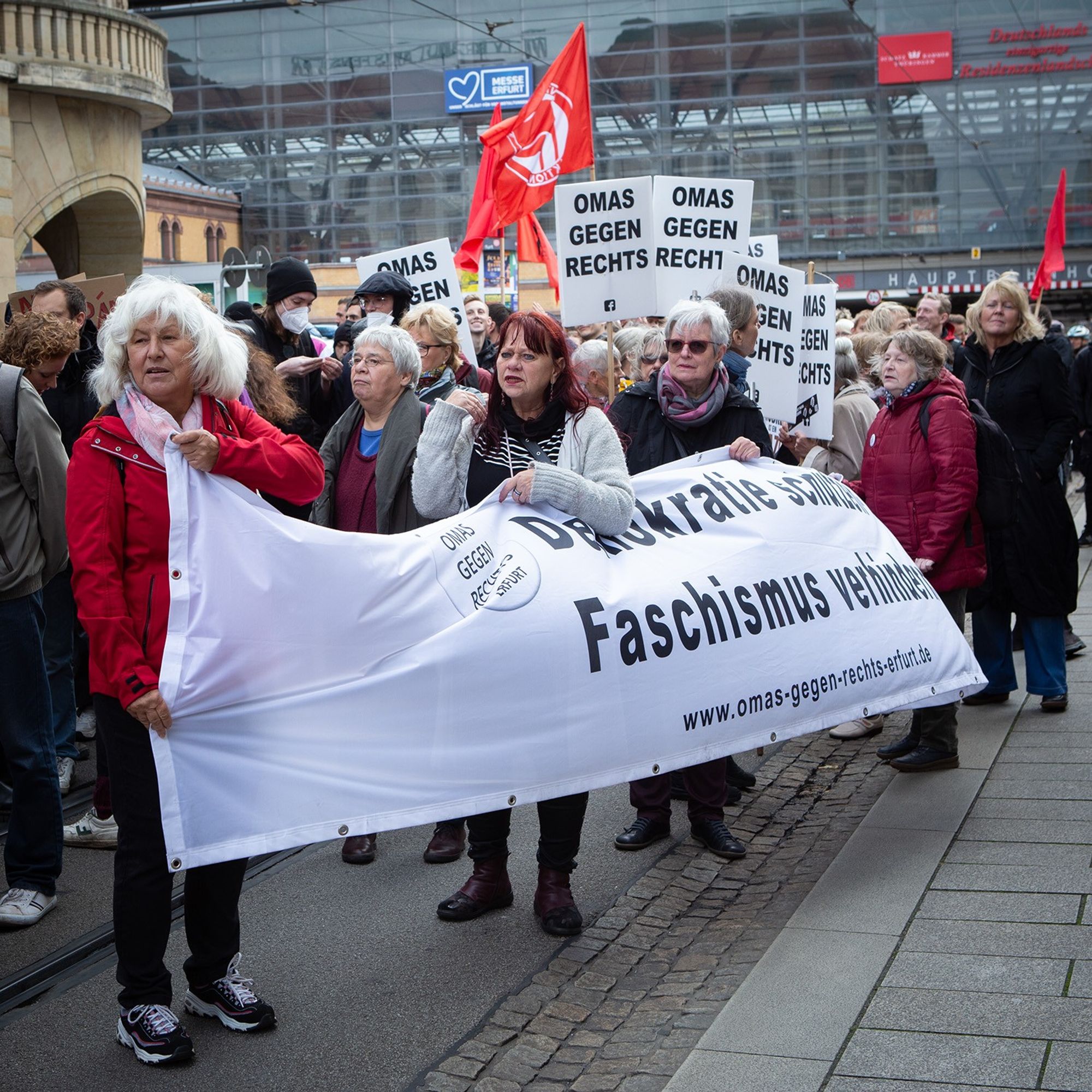 Demo gegen Rechts, zu sehen ist die Gruppe "Omas gegen Rechts", sie halten ein weißes Transparent "Demokratie stärken Faschismus verhindern"