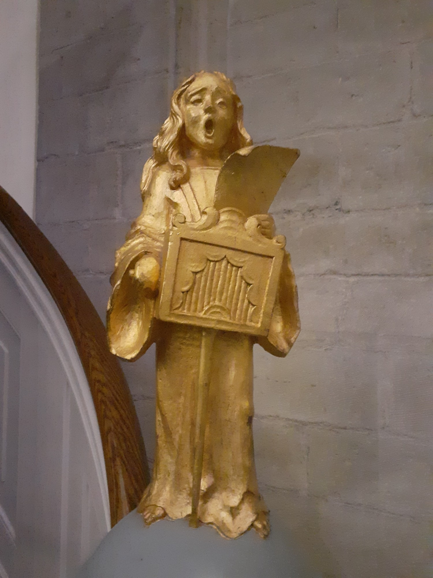 Golden singing angel with a portative, just under the organ of the Grote Kerk in Breda.