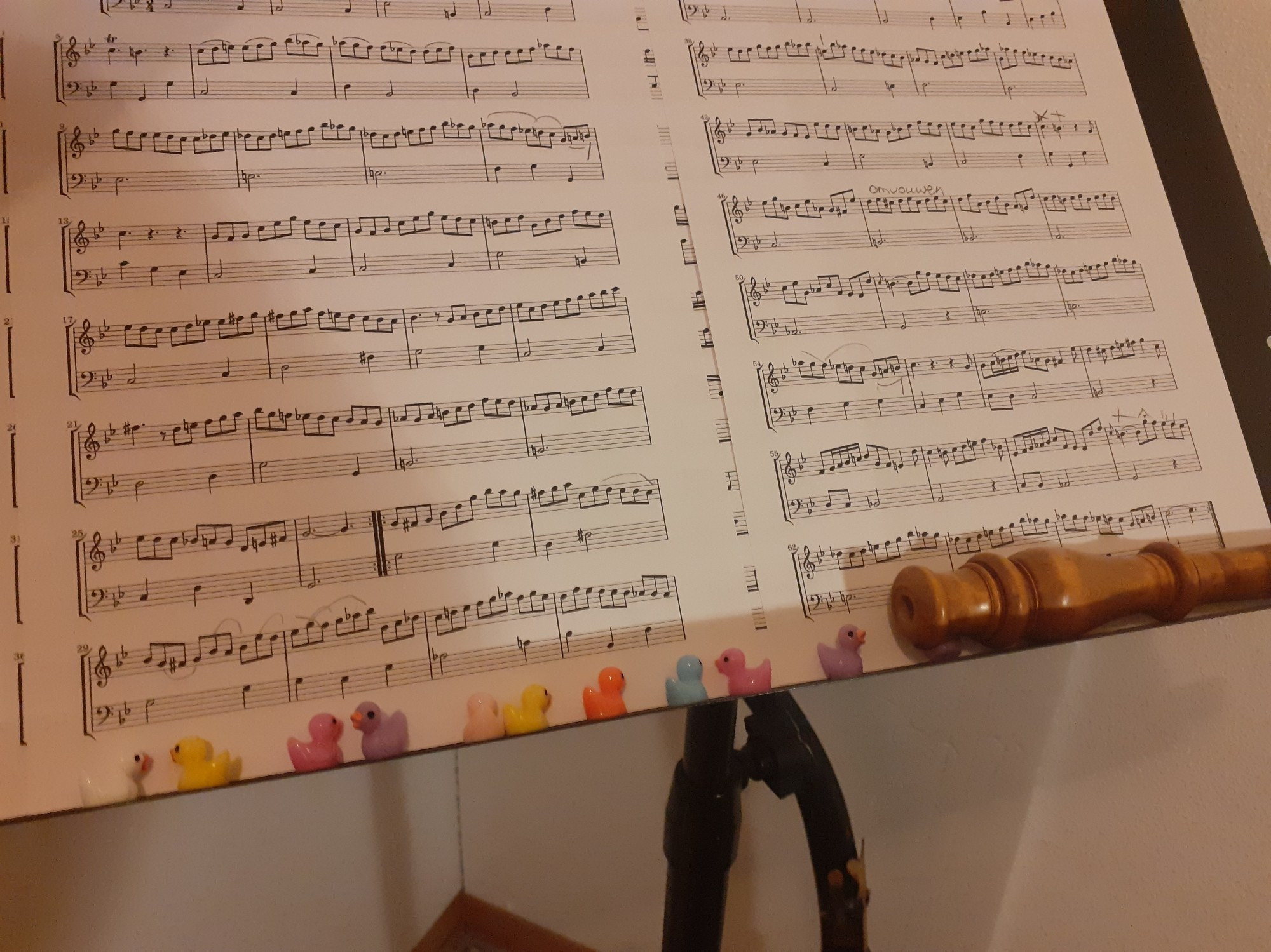 Sheet music on a stand with tiny bathtub ducks and a top joint of a baroque oboe