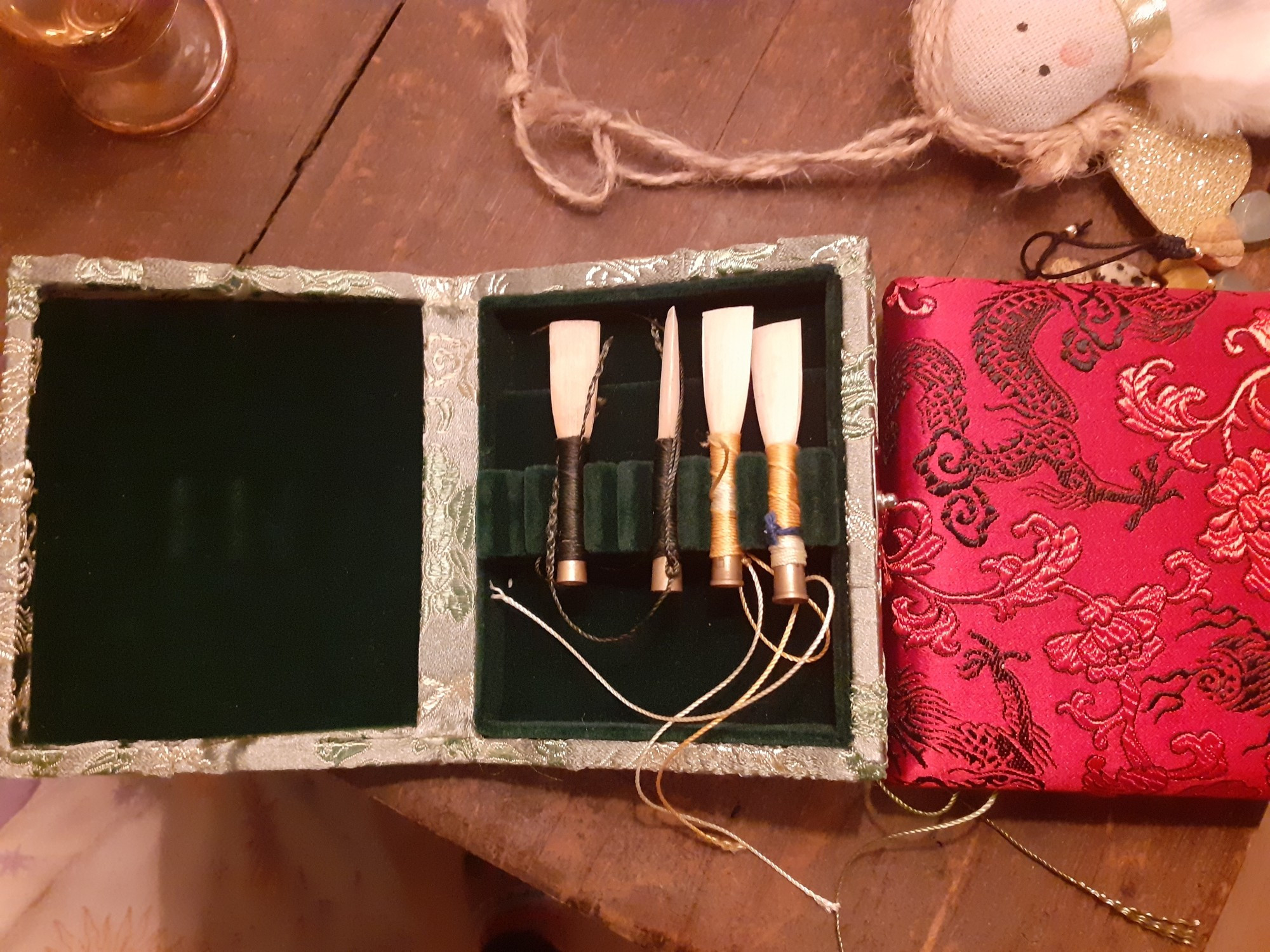 2 reed cases for oboe reeds, the green one is opened and filled with 4 baroque oboe reeds. The red is closed.