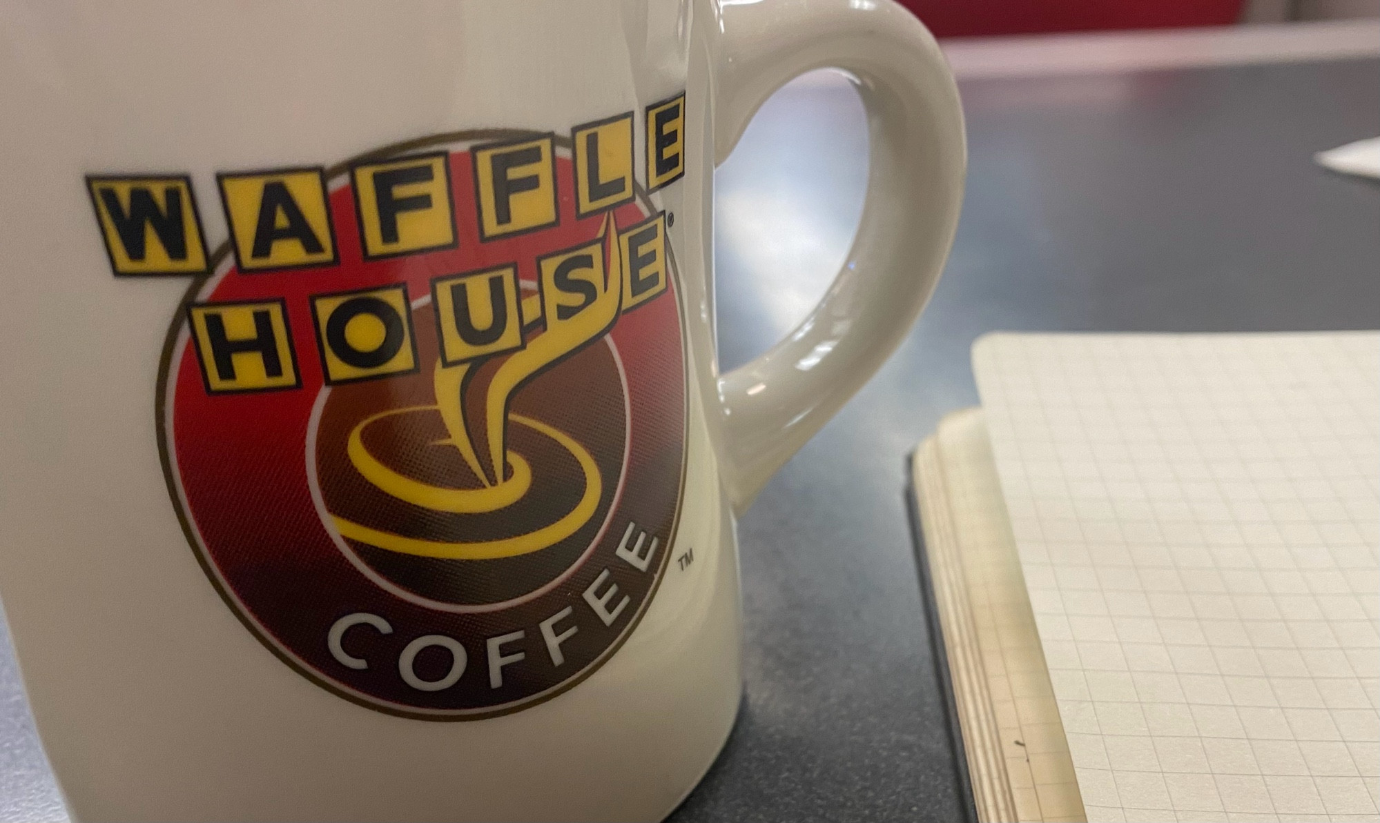 waffle house mug next to my notebook which is full of work