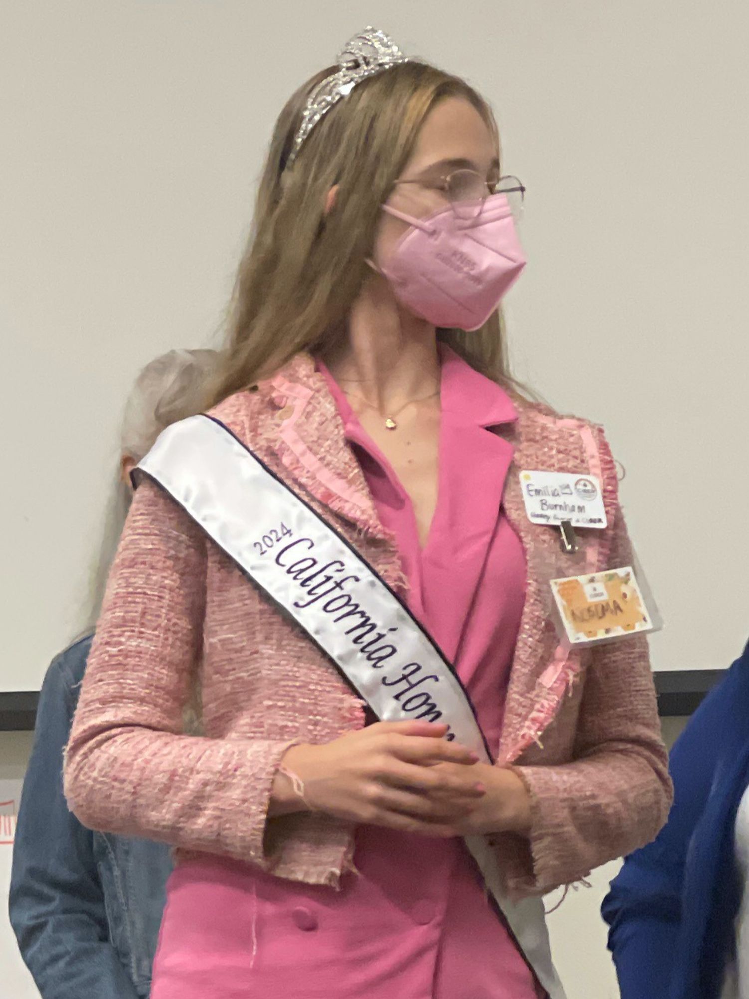 UC Riverside Center for Integrative Bee Research (CIBER) graduate student Emilia Burnham, Nosema ceranae researcher, attends the 2024 CIBER Bee Health conference in pink high heel shoes, pink dress, pink jacket, pink N95 mask, and 2024 California Honey Queen regalia (sash and crown). Don't dream it, be it.
Photo by Jacob Dickinson.