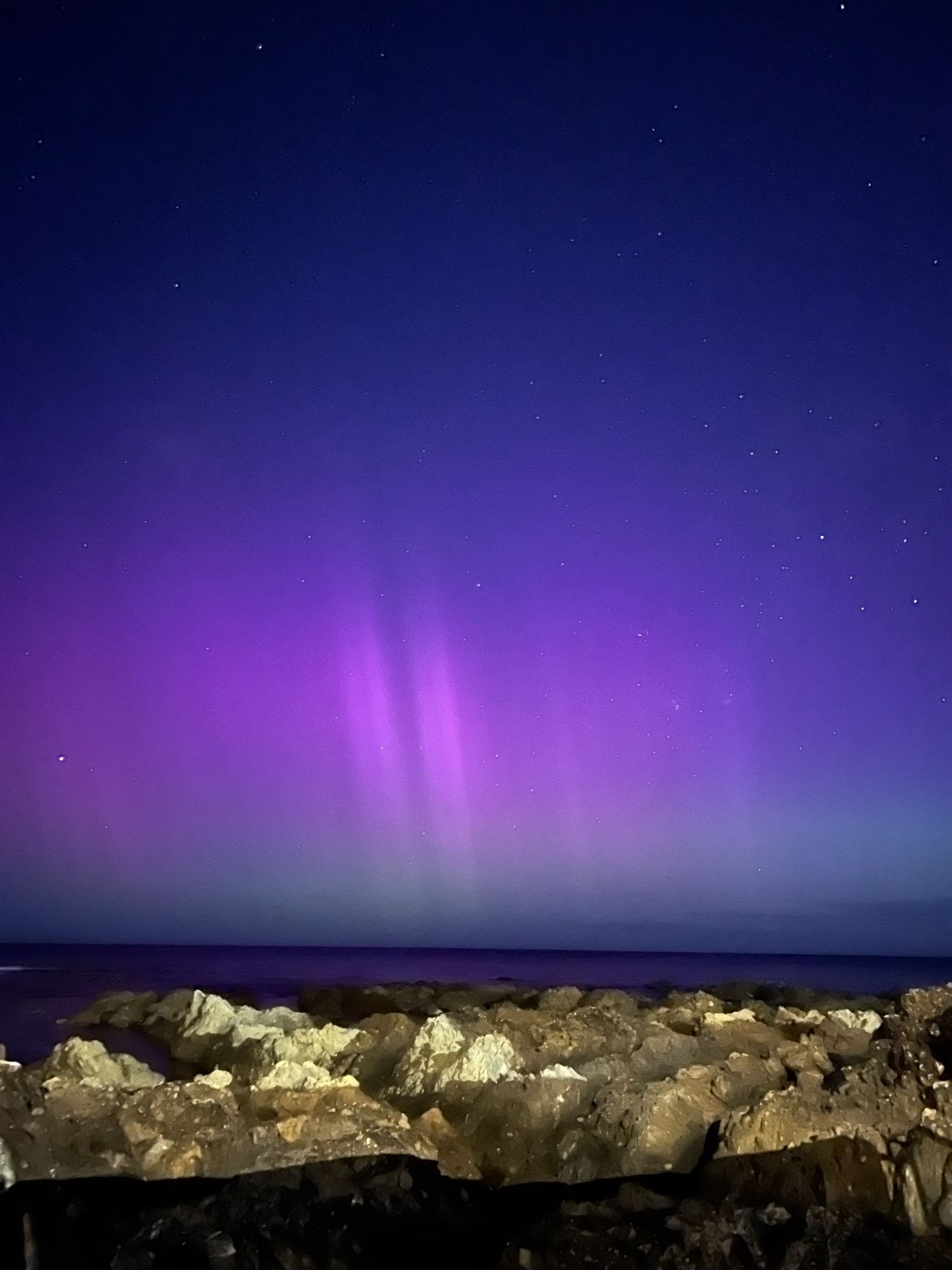 Purple and green Aurora. Diagonal vertical flares visible.