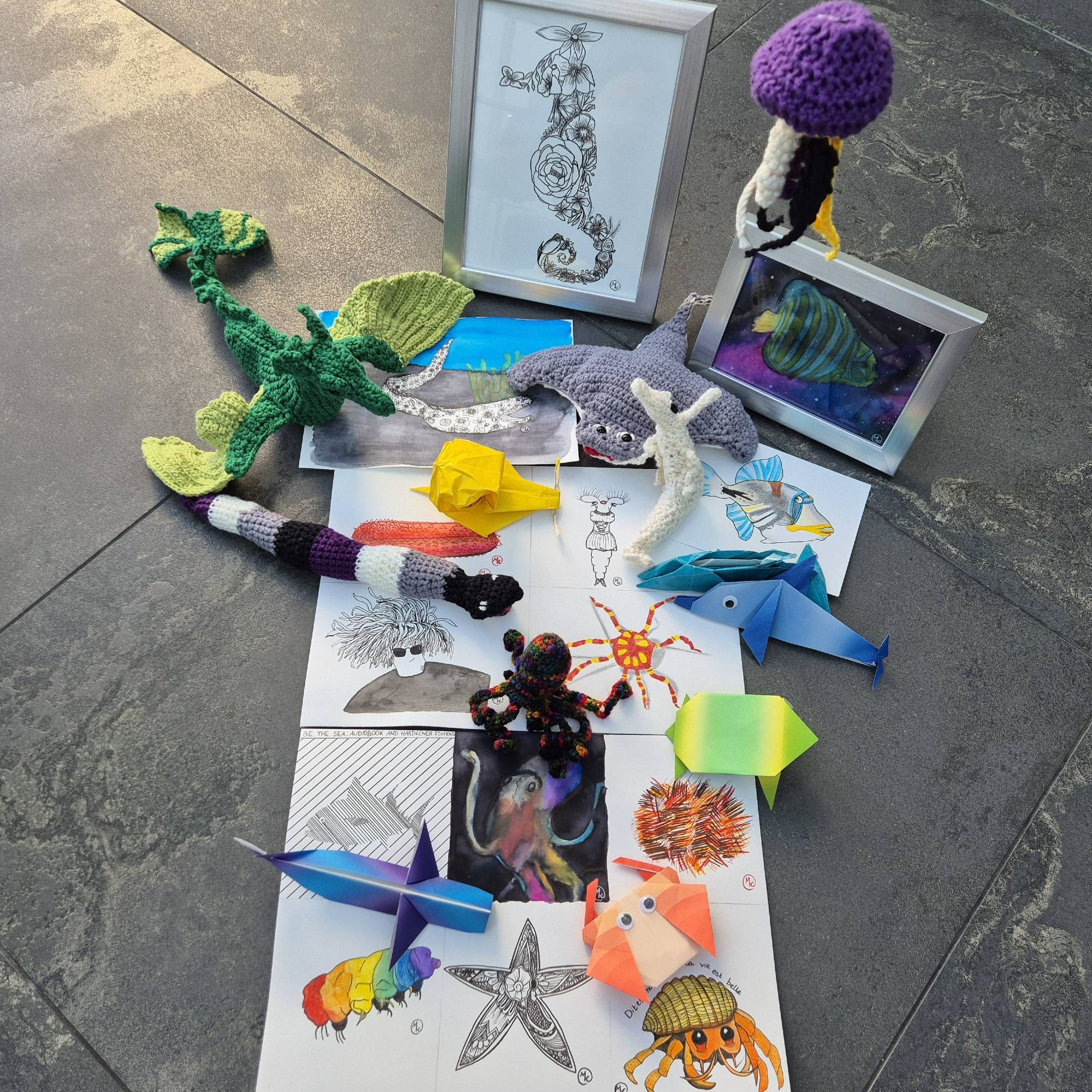 Photo of the Sea Creatures from the BE THE SEA campaign, including crocheted animals, pages with drawings and paintings, and origami animals.