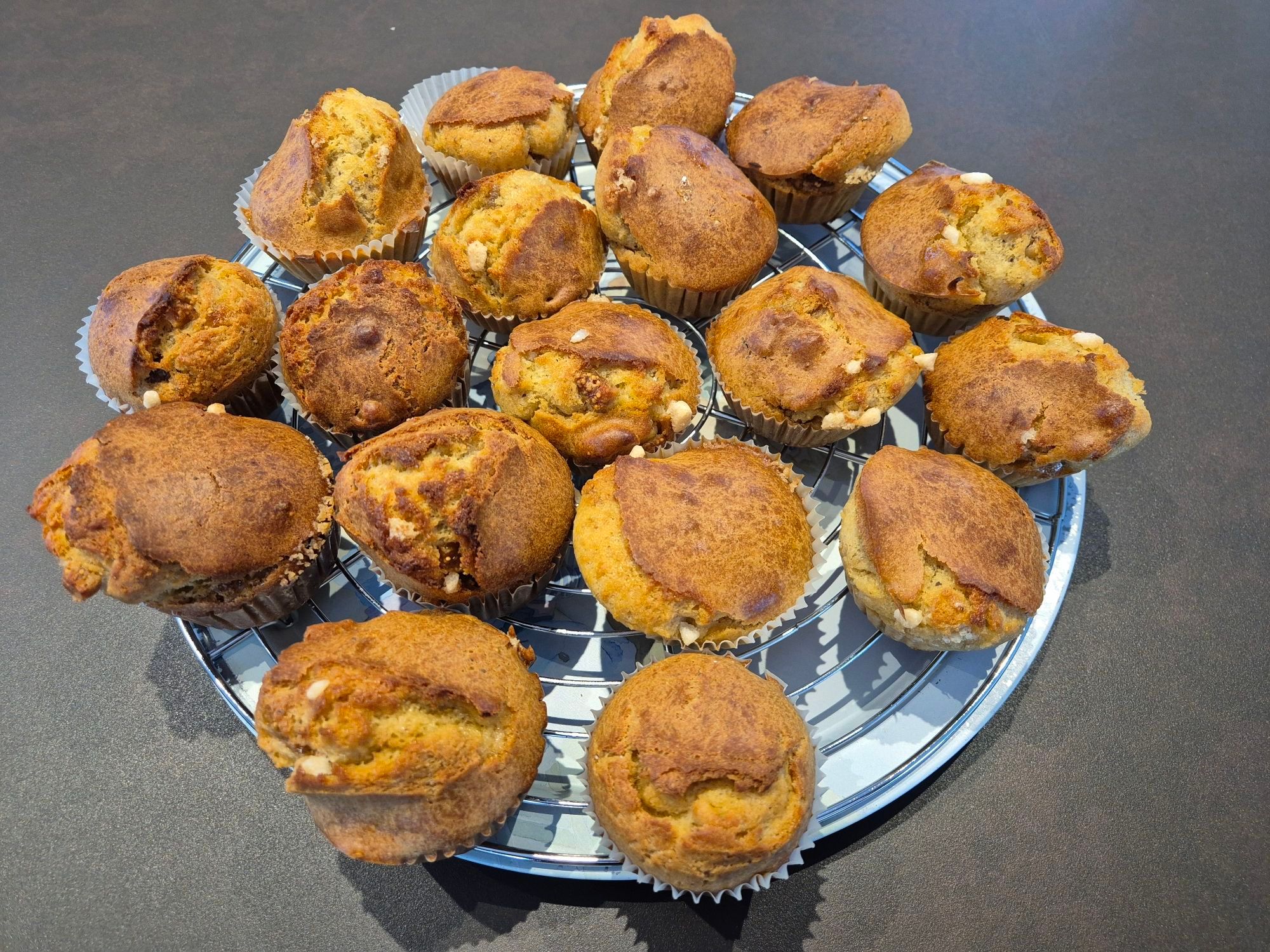 Photo of a round metal tray filled with golden-brown scones that have sugar pearls sticking out here and there.