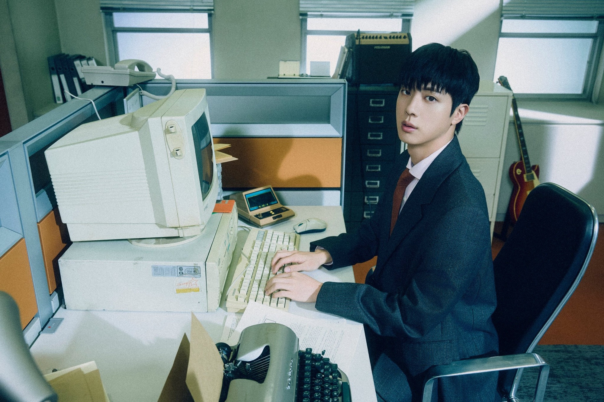 Seokjin in a corporate attire, in hisncubicle working