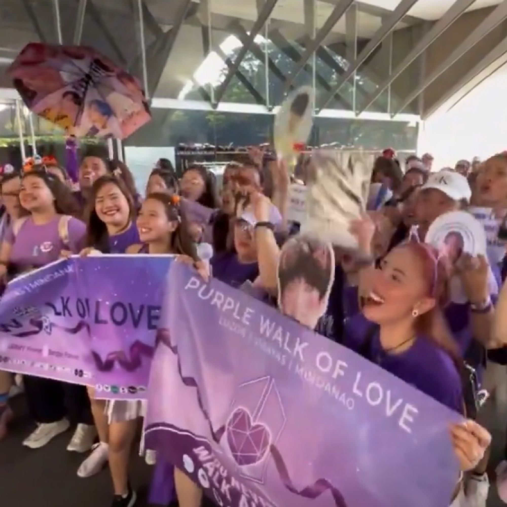 ARMY wearing purple holding up a banner that says ‘purple walk of love’ with purple ribbon