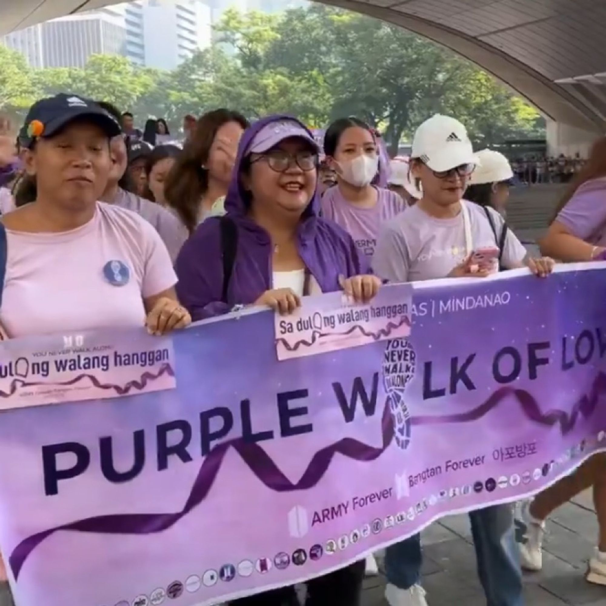 ARMY wearing purple holding up a banner that says ‘purple walk of love’ with purple ribbon