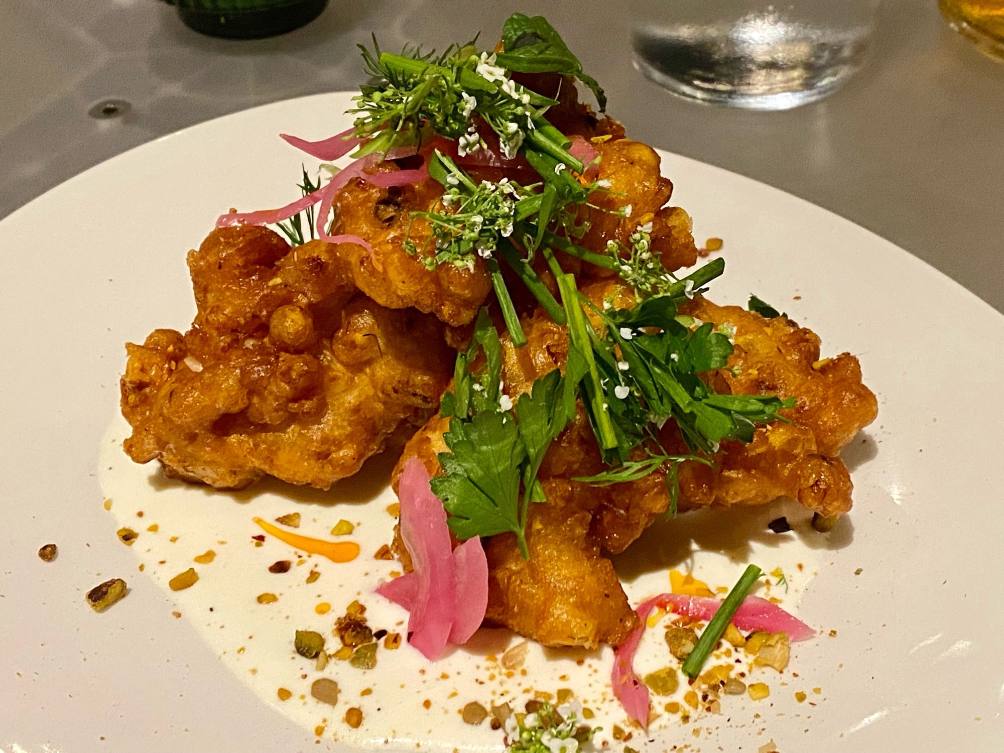 Crispy corn fritters with whipped feta labneh, scallion, sukkah, Aleppo oil, mint