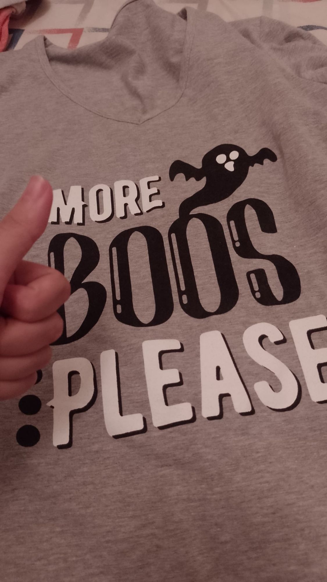 A T-shirt that says "MORE BOOS PLEASE" with a small ghost on it