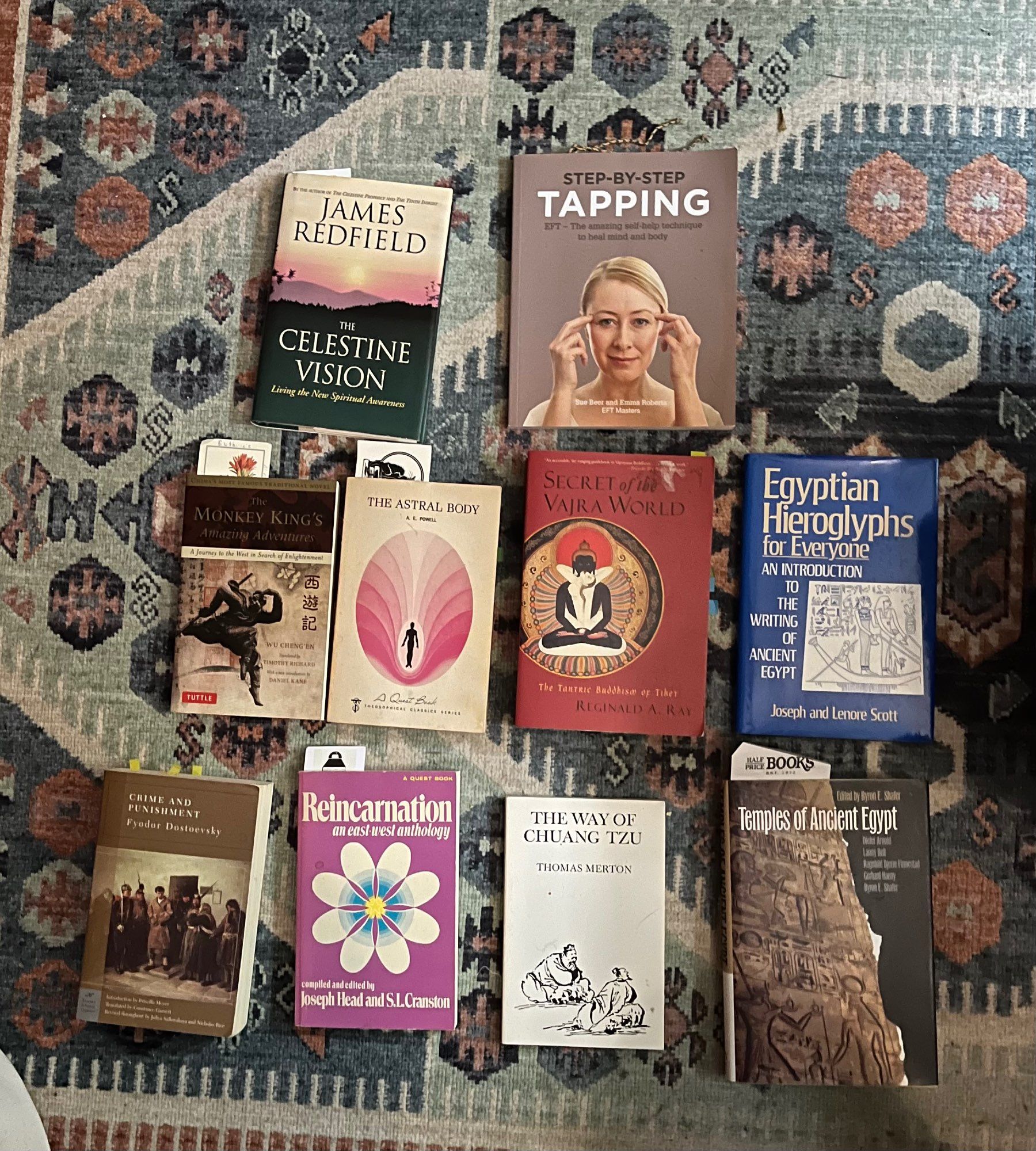 A selection of books on the floor: The Celestine Vision, Tapping, [Journey to the West], The Astral Body, Secret of the Vajra World, Egyptian Hieroglyphs for Everyone, Crime and Punishment, Reincarnation, The Way of Chuang Tzu, and Temples of Ancient Egypt