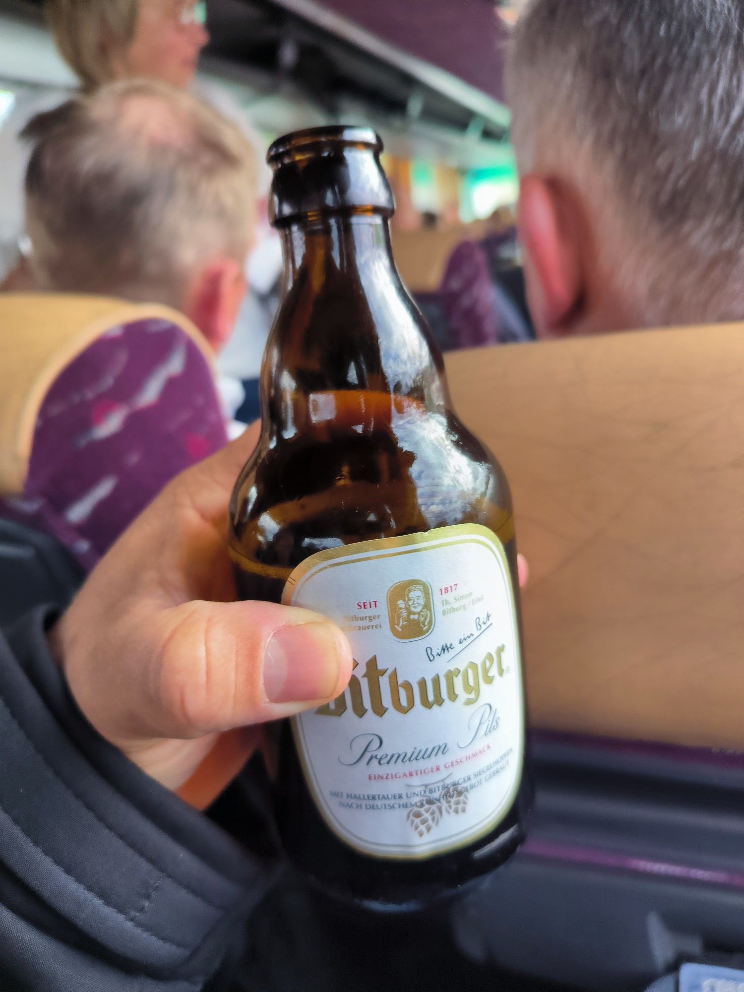 Man sieht meine Hand mit einer Flasche Bier.