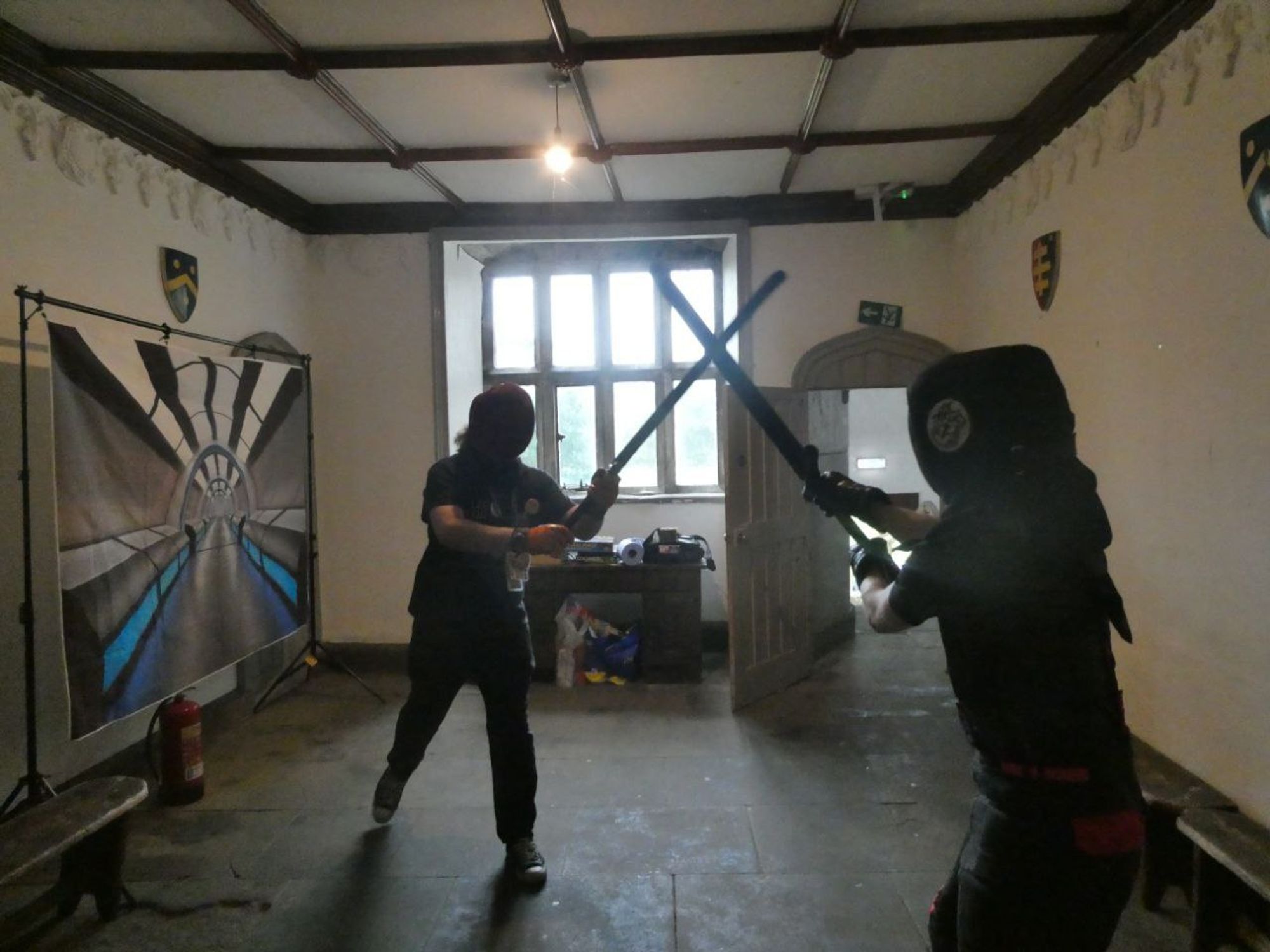 a couple wearing protective gear fencing using foam boffer swords