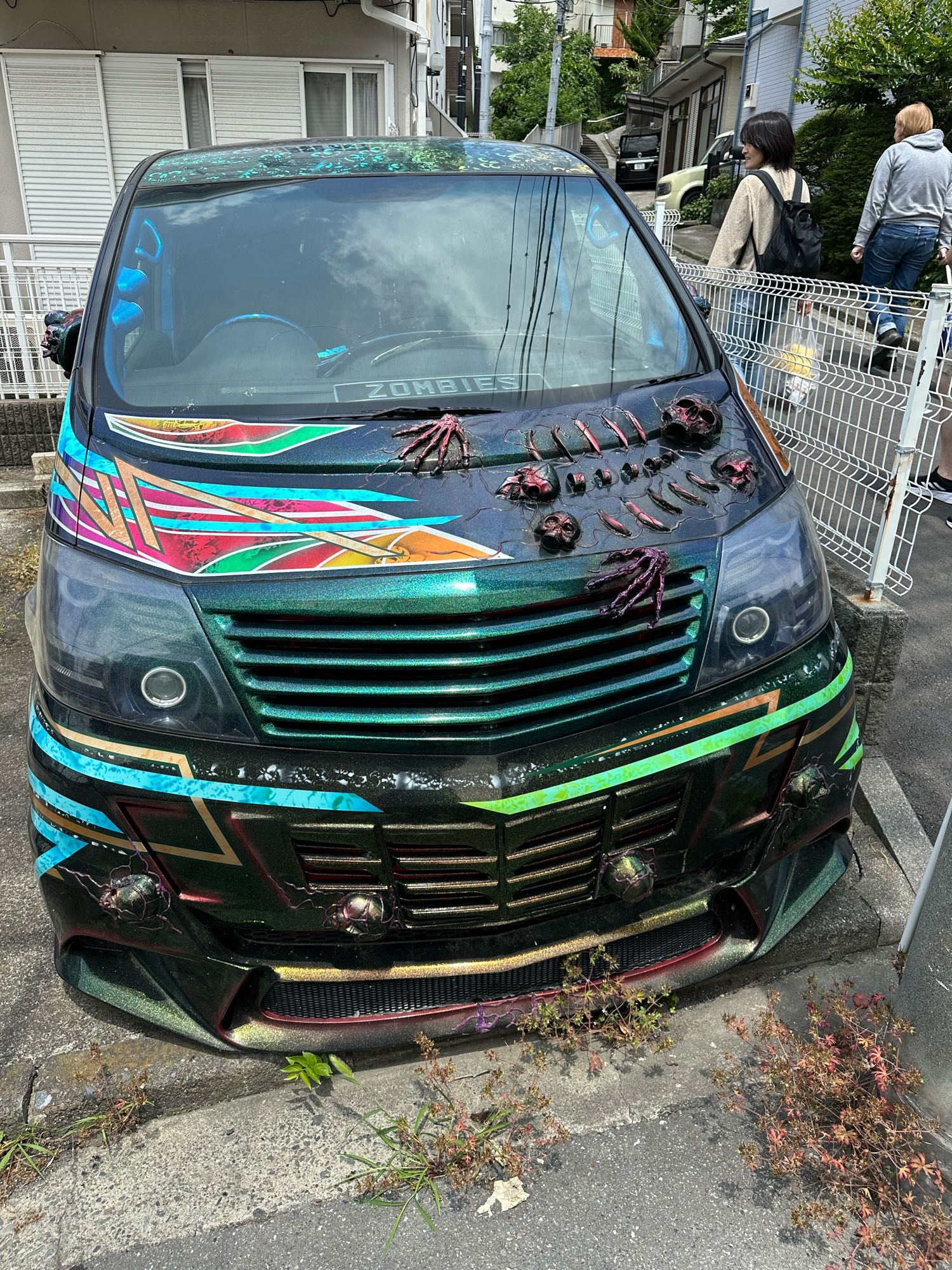 At first glance, you would believe this black car got wrinkled in some sort of accident. At a closer look, you realize it is a skeleton embedded into the hood. At several places along the fender is skulls embedded into the car body. In the front window lies a licence plate spelling out ZOMBIE.