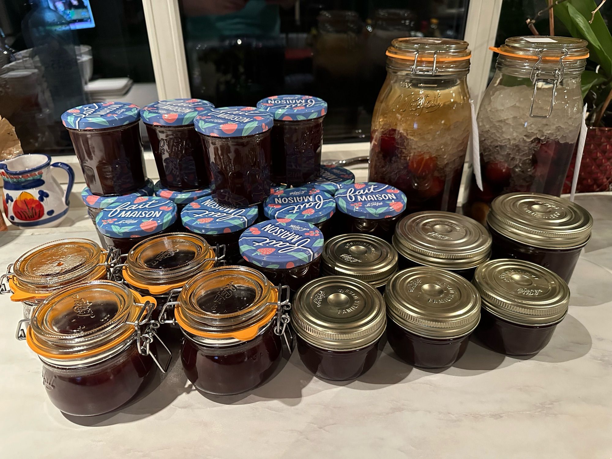 Many jars of red plum jam and two jars of red plum liquor.