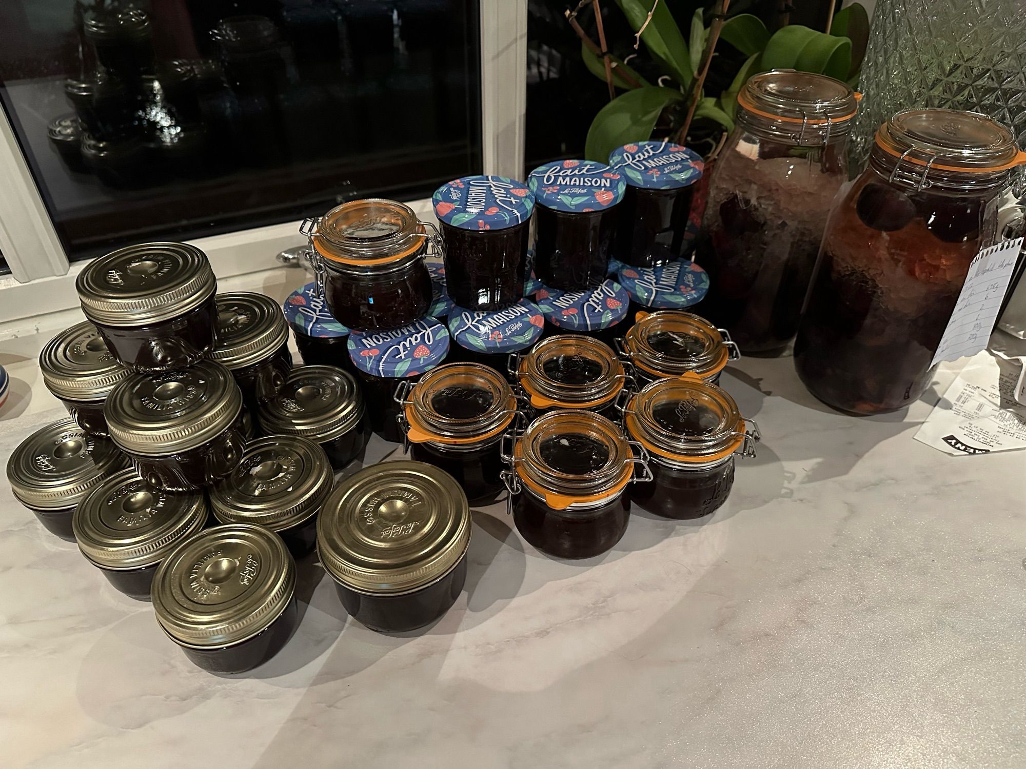 Many jars of purple plum jam and two jars of purple plum liquor.