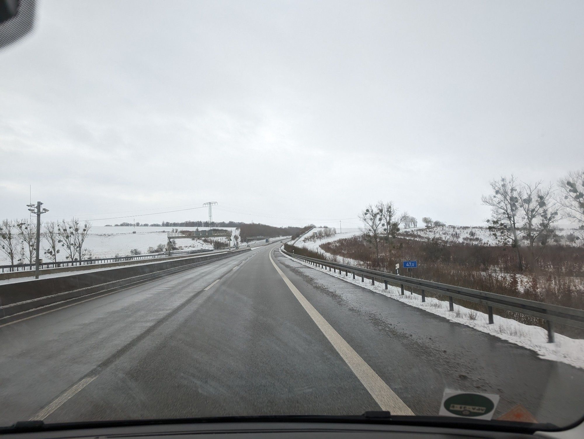 Empty highway with snow-covered hills on both sides