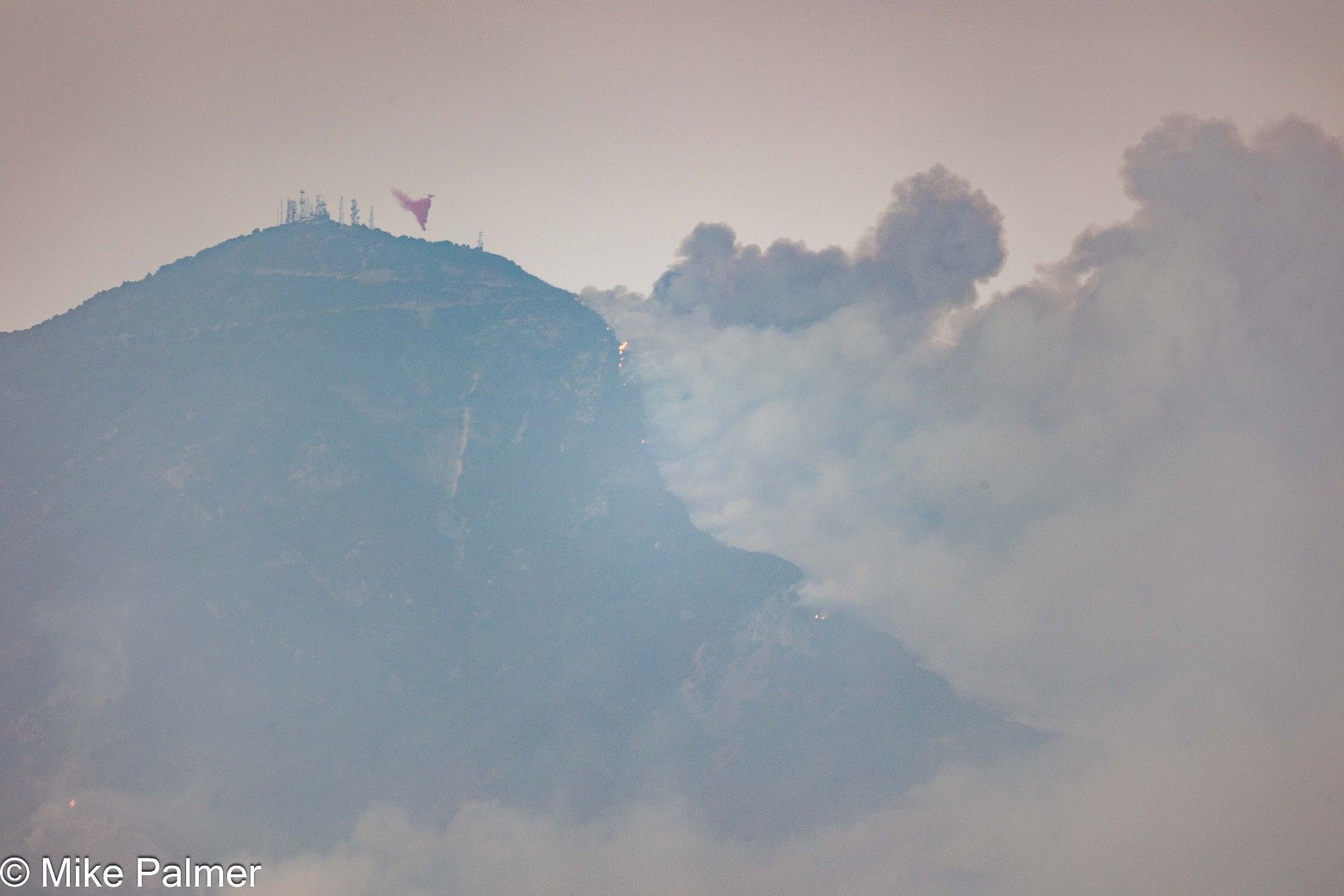 A tanker drops fire retardant near the Santiago peak, as fire works its way up the southern side of the mountain.