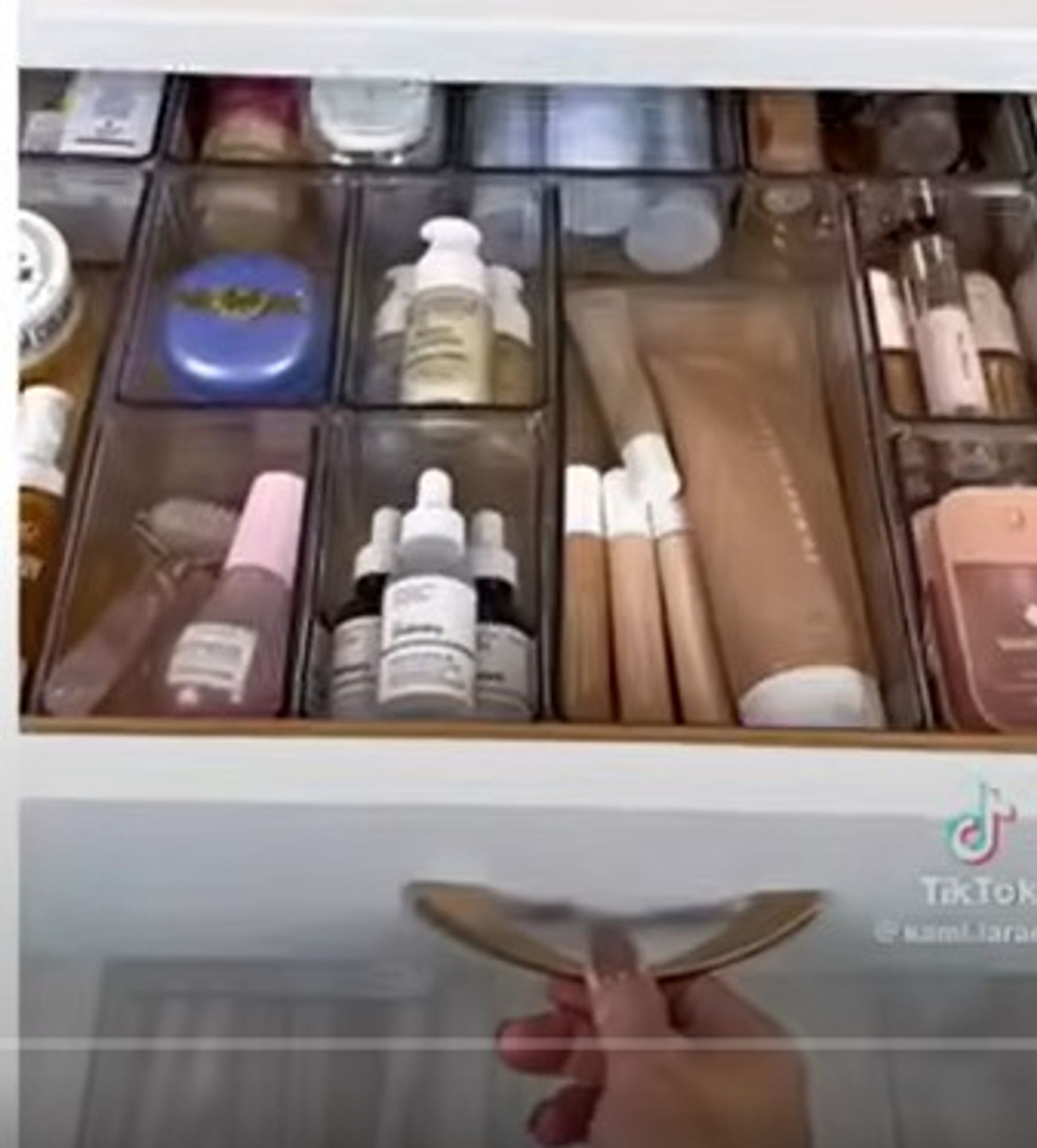 from a restock tiktok: bathroom drawer divided into compartments filled with high end beauty and skincare supplies