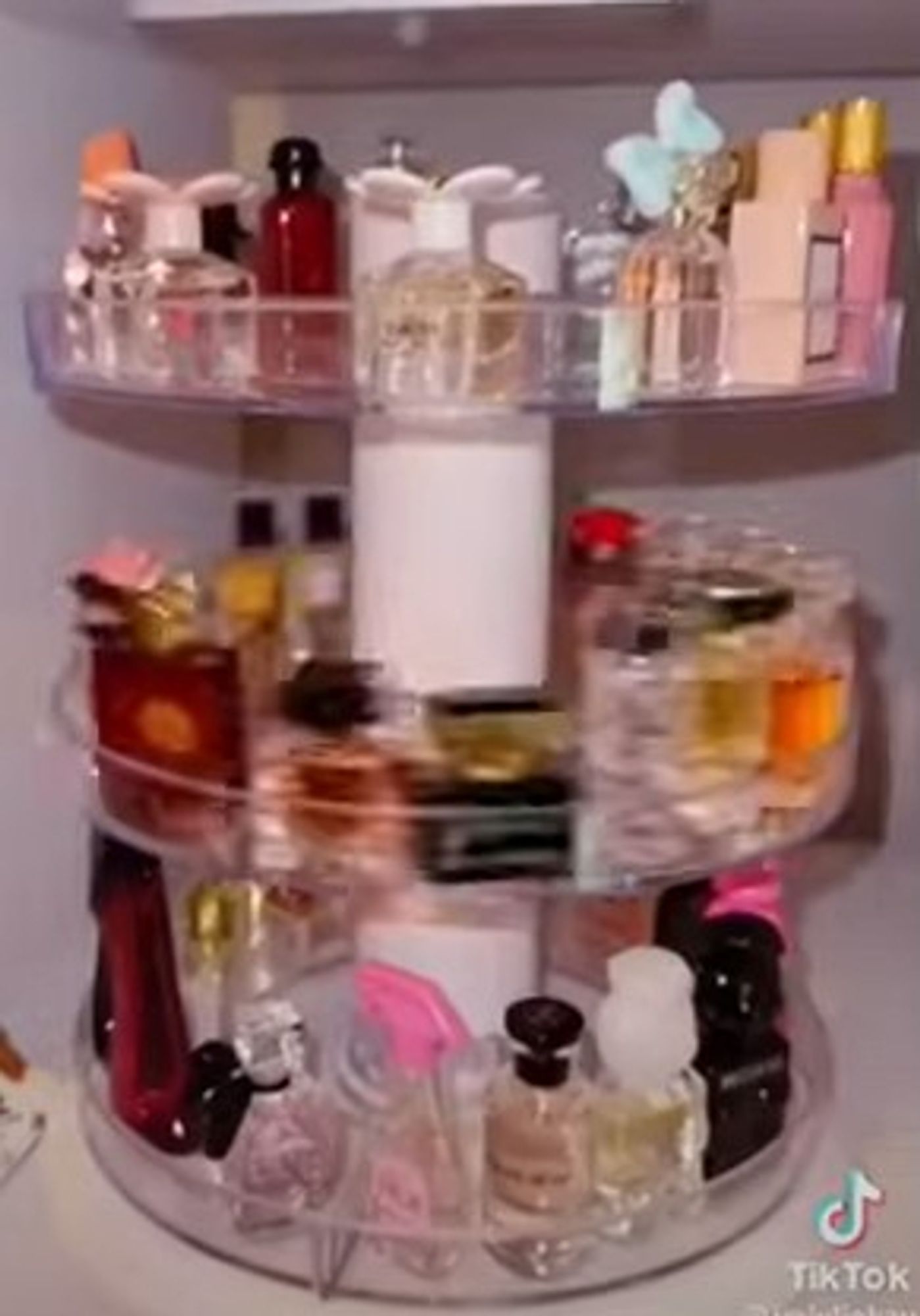 from a restock tiktok: spinning organizer filled with three racks of perfume