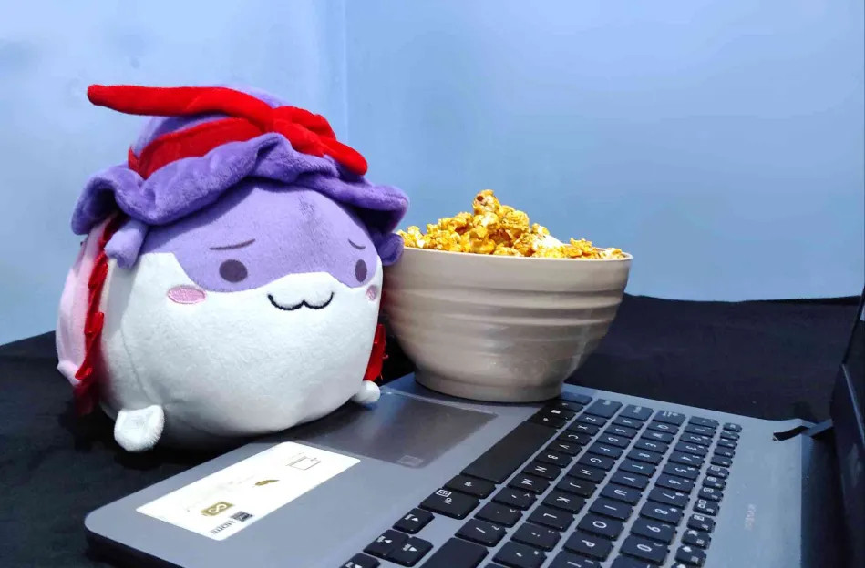 Iku sukusuku enjoying her popcorn while witnessing something on the laptop