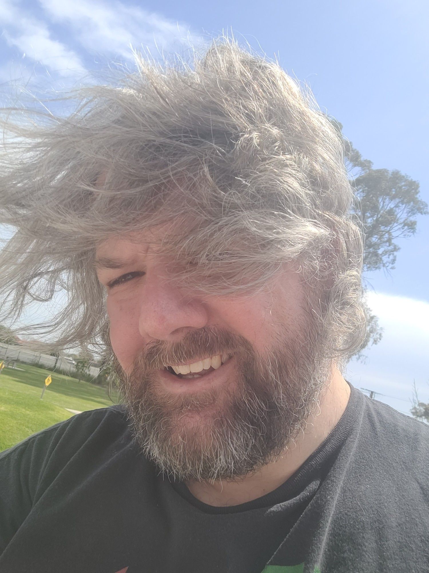 MMG, face almost obscured by wind blown grey hair