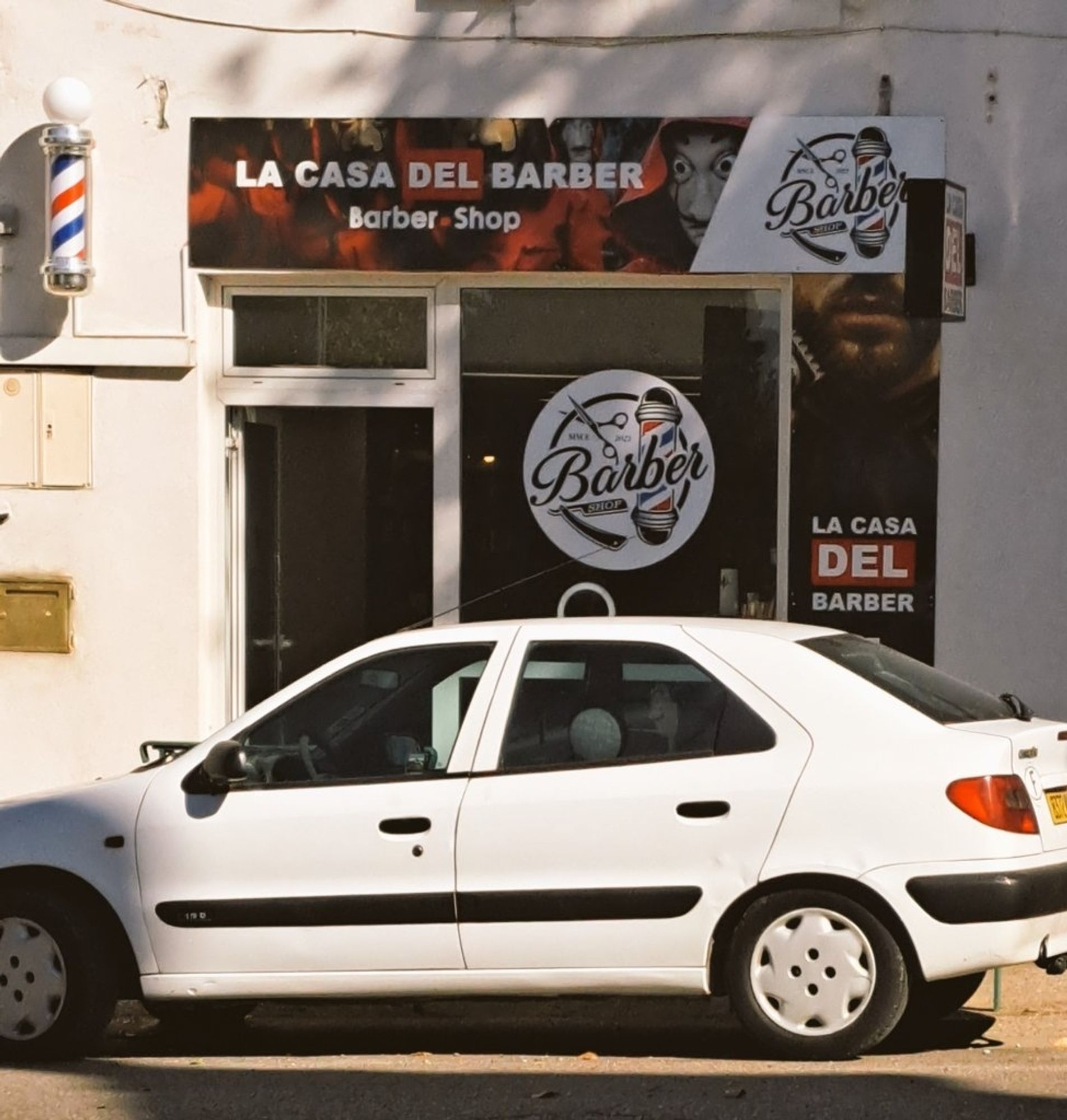 Photo d'une devanture d'un barbier nommé "la casa del barber" en référence à série "la Casa de Papel", des images de la série sont d'ailleurs utilisées en bannière.