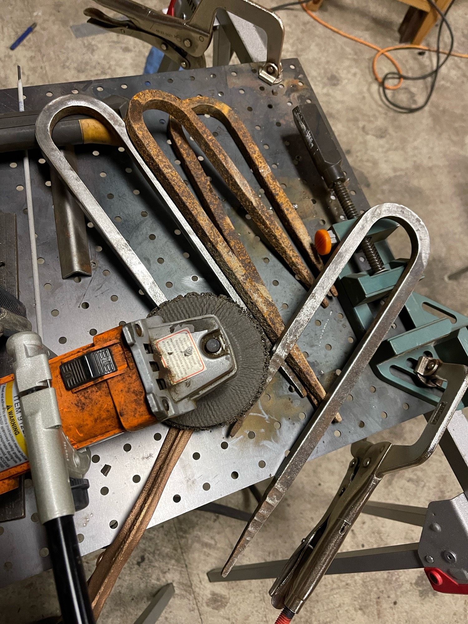 Metal grinder with spikes that have been partially cleaned to show progress in a project.