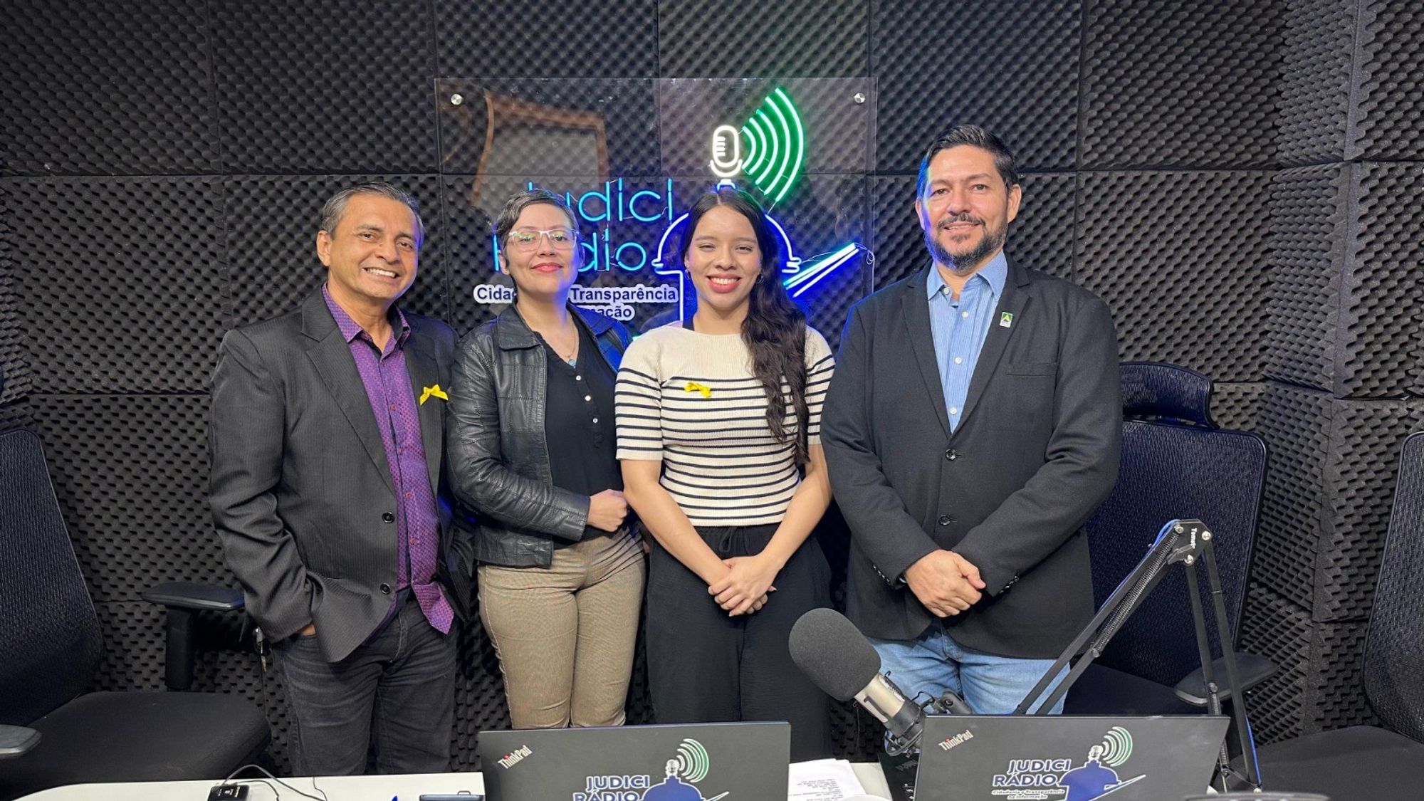 Fotografia dos apresentadores do Programa JudiciRádio Notícias e o entrevistado. São dois homens e duas mulheres na foto, todos estão na bancada do programa