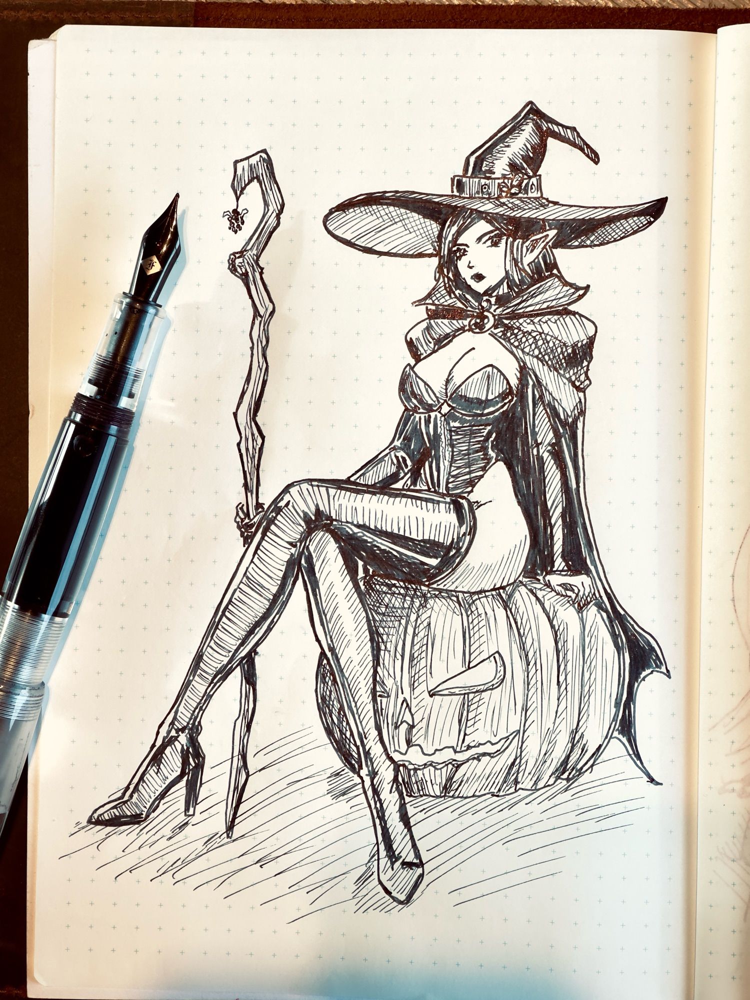 A fountain pen sketch of an elf woman in a sexy witch costume, holding a staff and sitting on a jack o’ lantern. Opus 88 Omar pen. Wearingeul Black Dream ink.