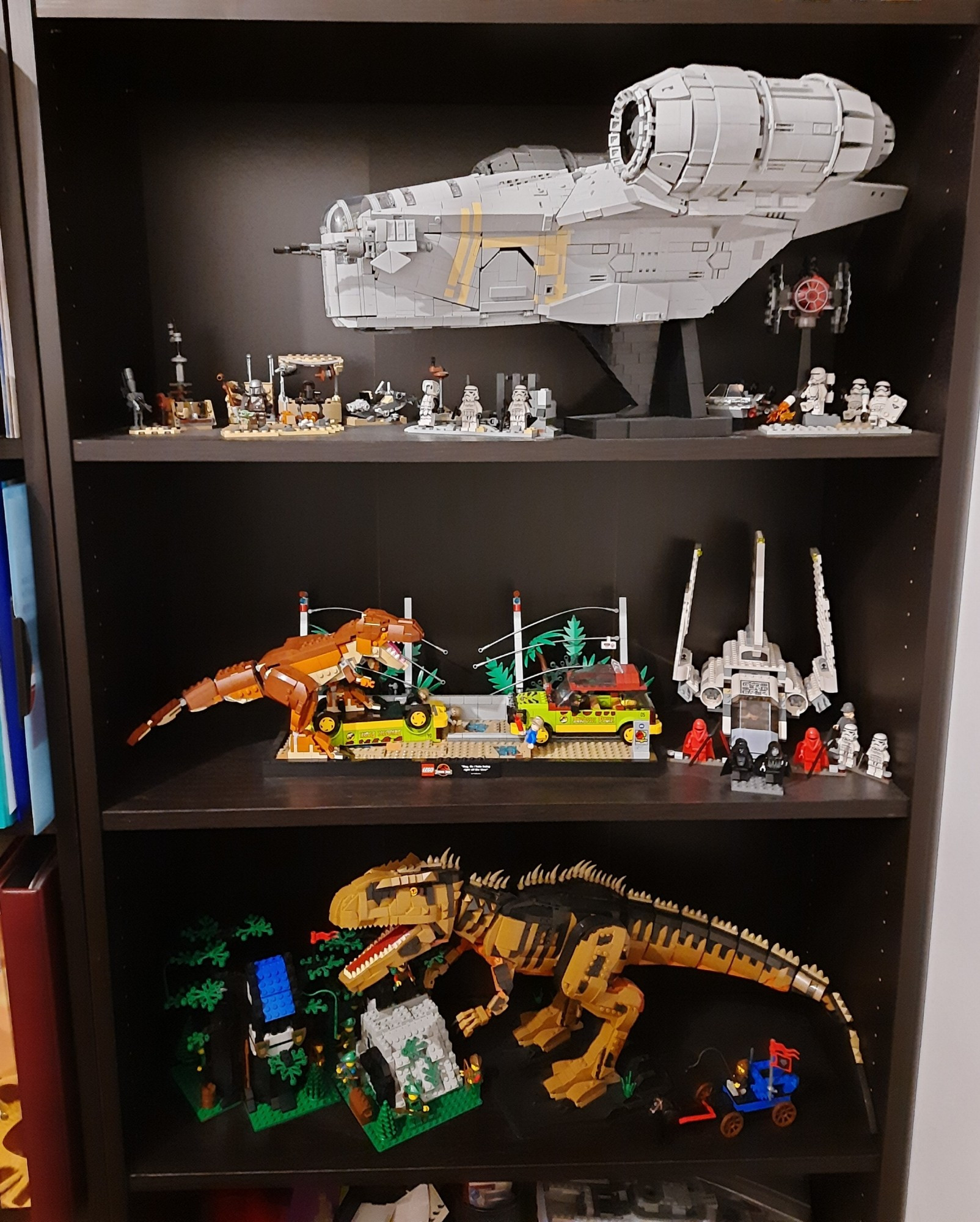 Billy Regal voll mit Klemmbaustein Sets. U.a. eine große Razor Crest von Moldking mit ein paar Star Wars Figuren von Lego, das T-Rex Breakout Diorama von Lego, der Giganotosaurus von Forange und 2 alte Forestmen Sets von Lego aus den 80ern.