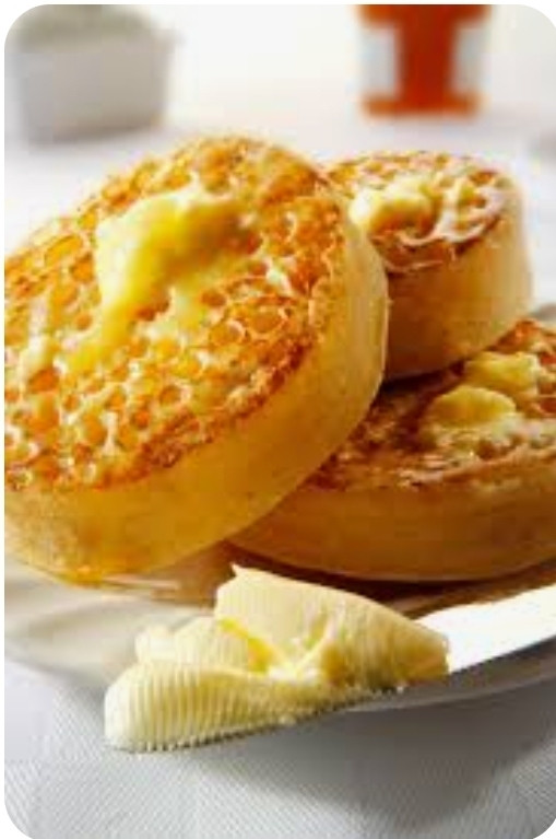 3 golden, delicious looking buttered crumpets on a plate