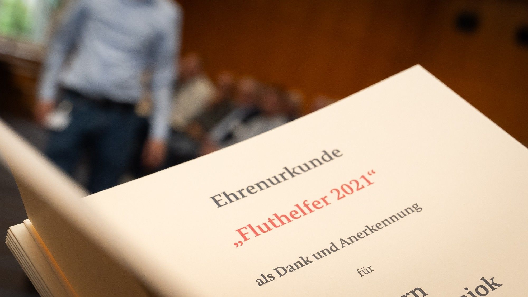 Nahaufnahme einer Urkunde, die von Volker Wissing überreicht wurde. Man kann folgendes lesen: Ehrenurkunde "Fluthelfer 2021" als Dank und Anerkennung für.