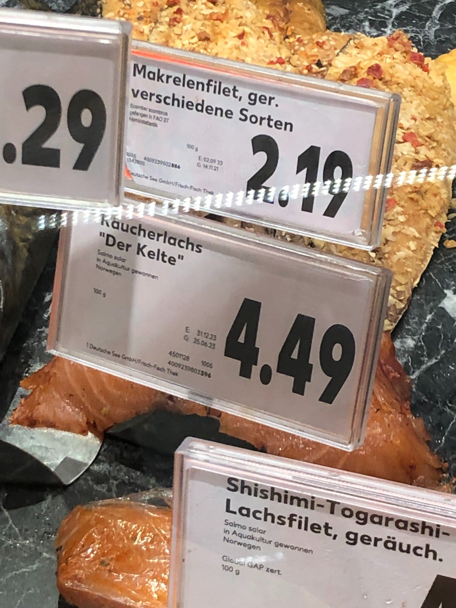 Zu sehen ist eine Fischauslage im Geschäft, auf einem Schild steht: Räucherlachs "Der Kelte"