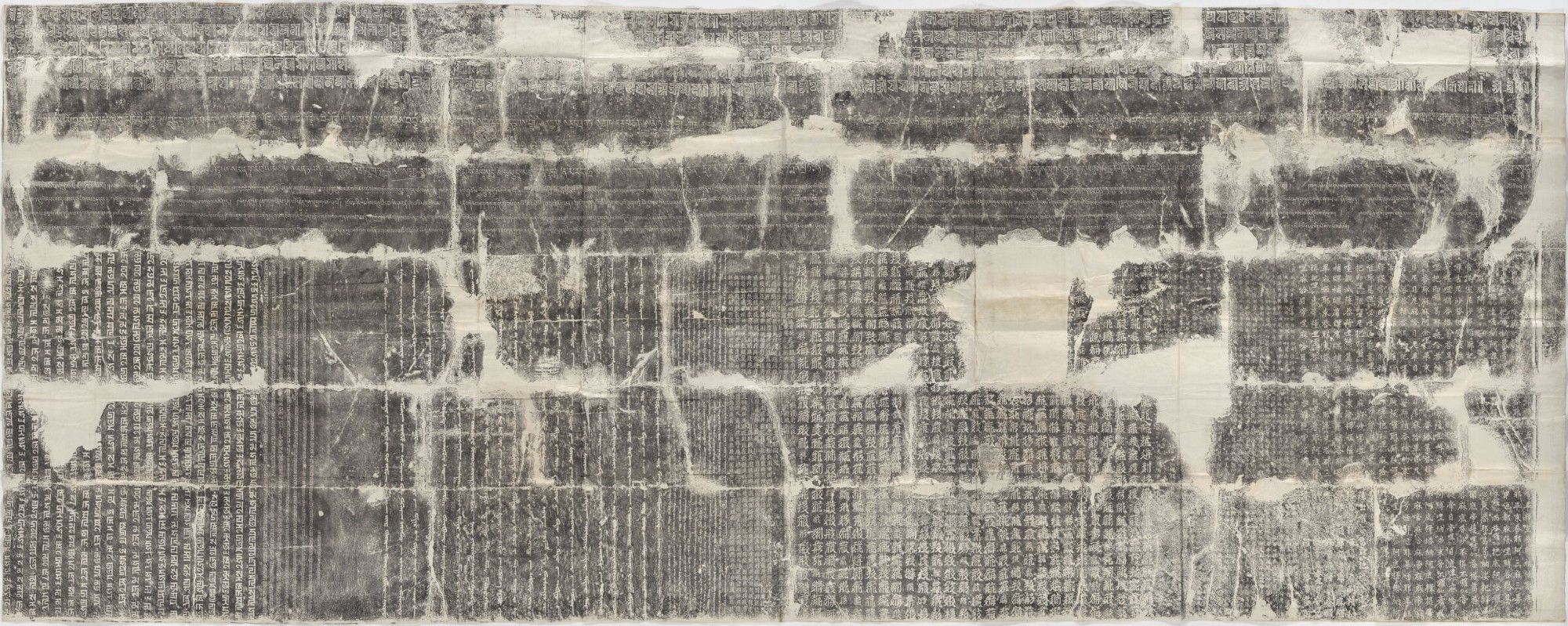 Rubbing of the inscriptions on the inner east wall of the arch at Juyong Pass, showing Lanydza script running horizontally left-to right along the top, Tibetan script running horizontally left-to right below it, Phags-pa script on the outer left section in vertical columns running left-to-right, Old Uyghur script on the inner left section in vertical columns running left-to-right, Tangut script on the inner right section in vertical columns running right-to-left, and Chinese script on the outer right section in vertical columns running right-to-left