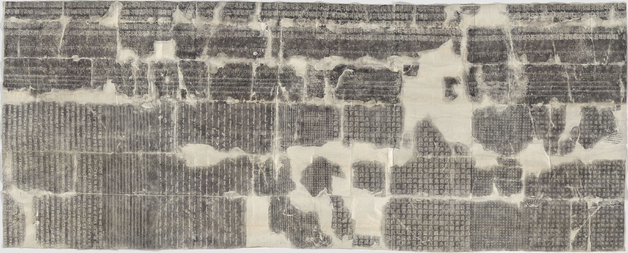 Rubbing of the inscriptions on the inner west wall of the arch at Juyong Pass, showing Lanydza script running horizontally left-to right along the top, Tibetan script running horizontally left-to right below it, Phags-pa script on the outer left section in vertical columns running left-to-right, Old Uyghur script on the inner left section in vertical columns running left-to-right, Tangut script on the inner right section in vertical columns running right-to-left, and Chinese script on the outer right section in vertical columns running right-to-left