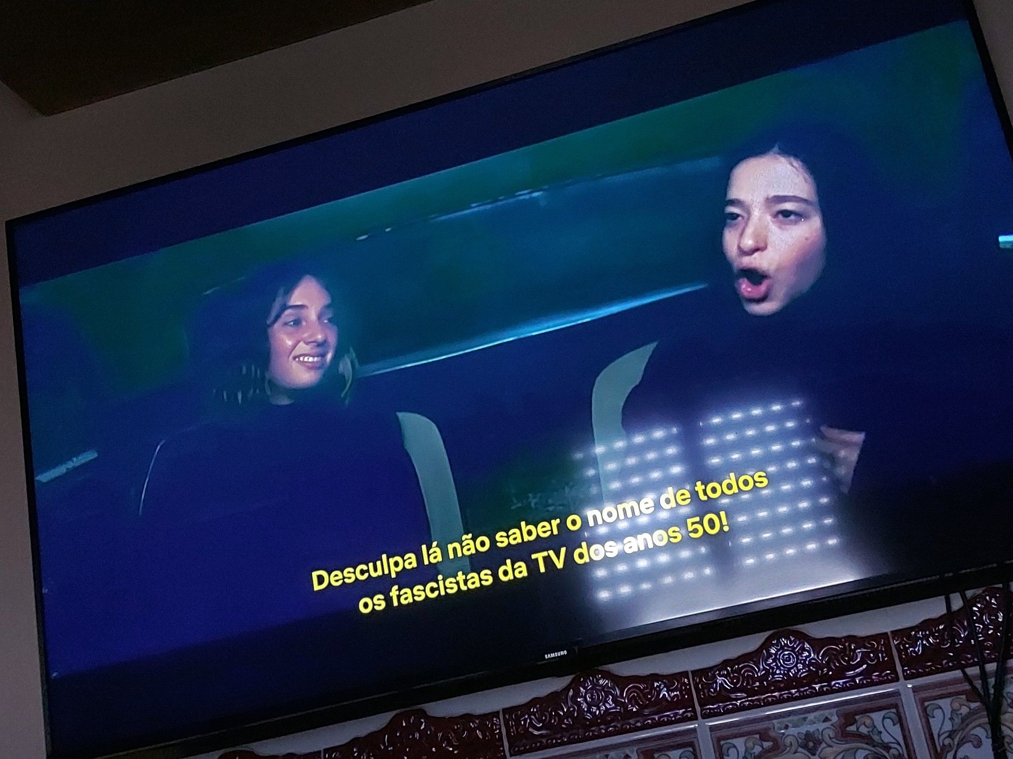 Two girls sitting in a dark car.