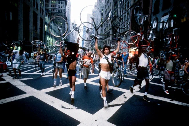Photo of bike messengers protesting in New York City by marching down the middle of a street with their bicycles raised over their heads.

More info: https://nyc.streetsblog.org/2012/08/07/the-bicycle-uprising-remembering-the-midtown-bike-ban-25-years-later