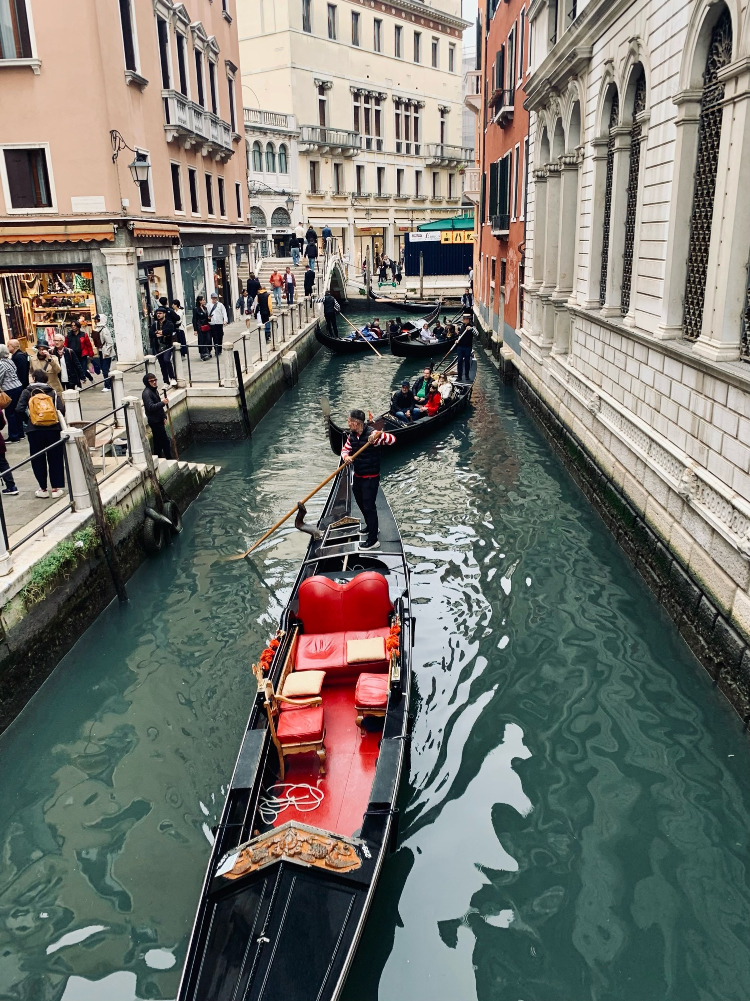 A canal in Venice filled with several gondolas. 