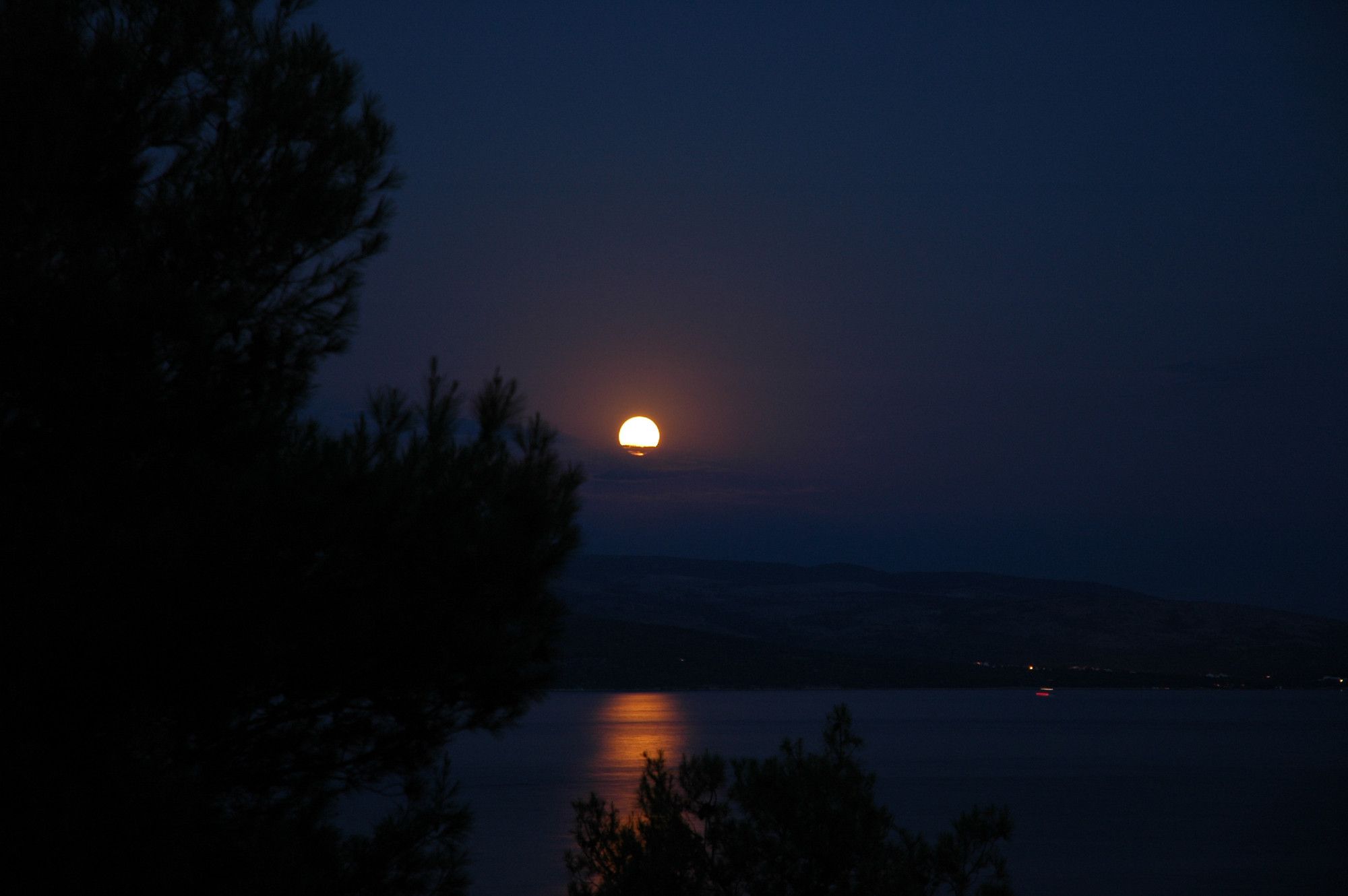 Untergehender Mond spiegelt sich im Meer