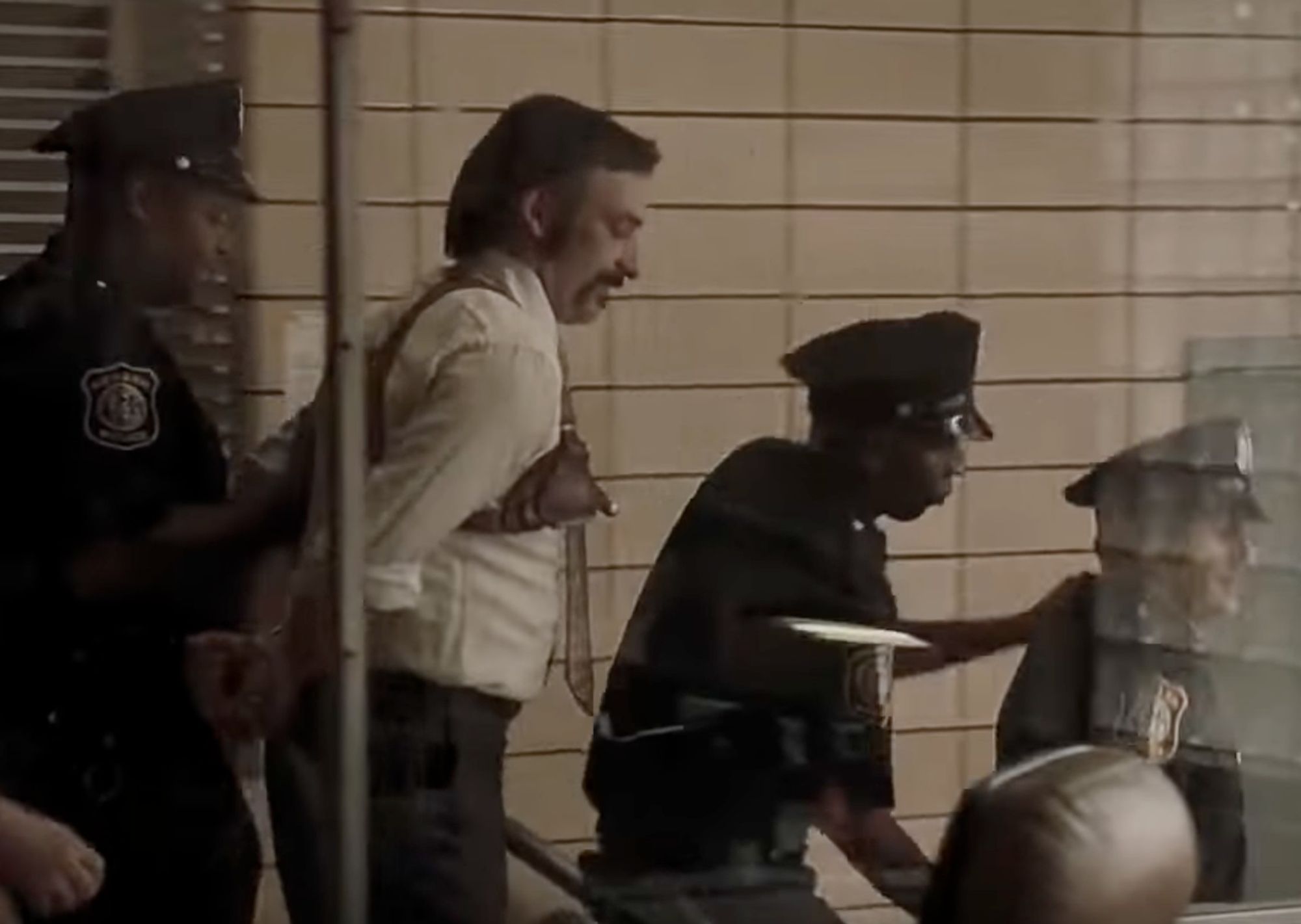 Still from the film American Gangster.  Two police officers are being arrested by two other police officers in a police precinct.