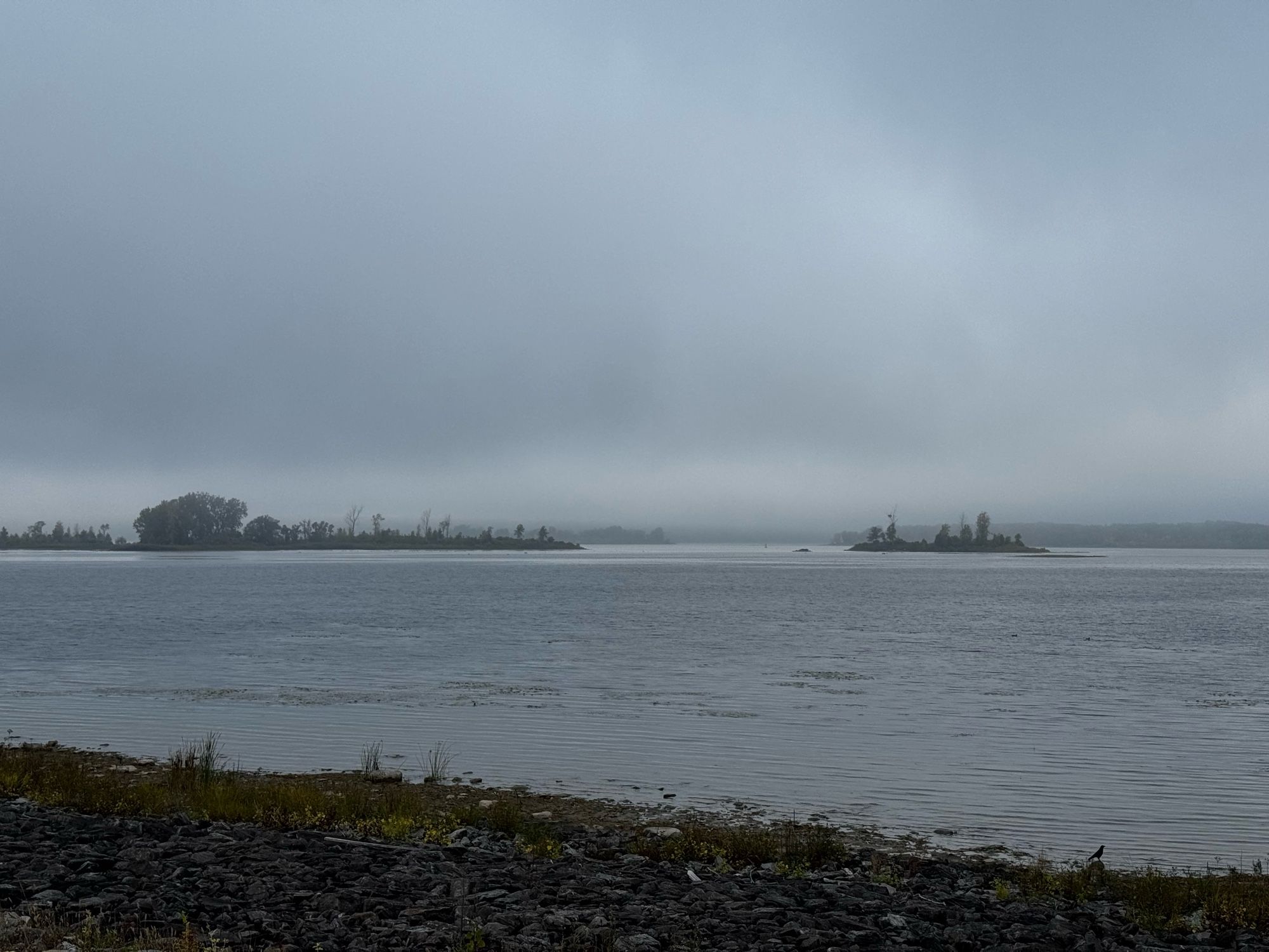 Another photo of cloudy skies. Rocks in the foreground.