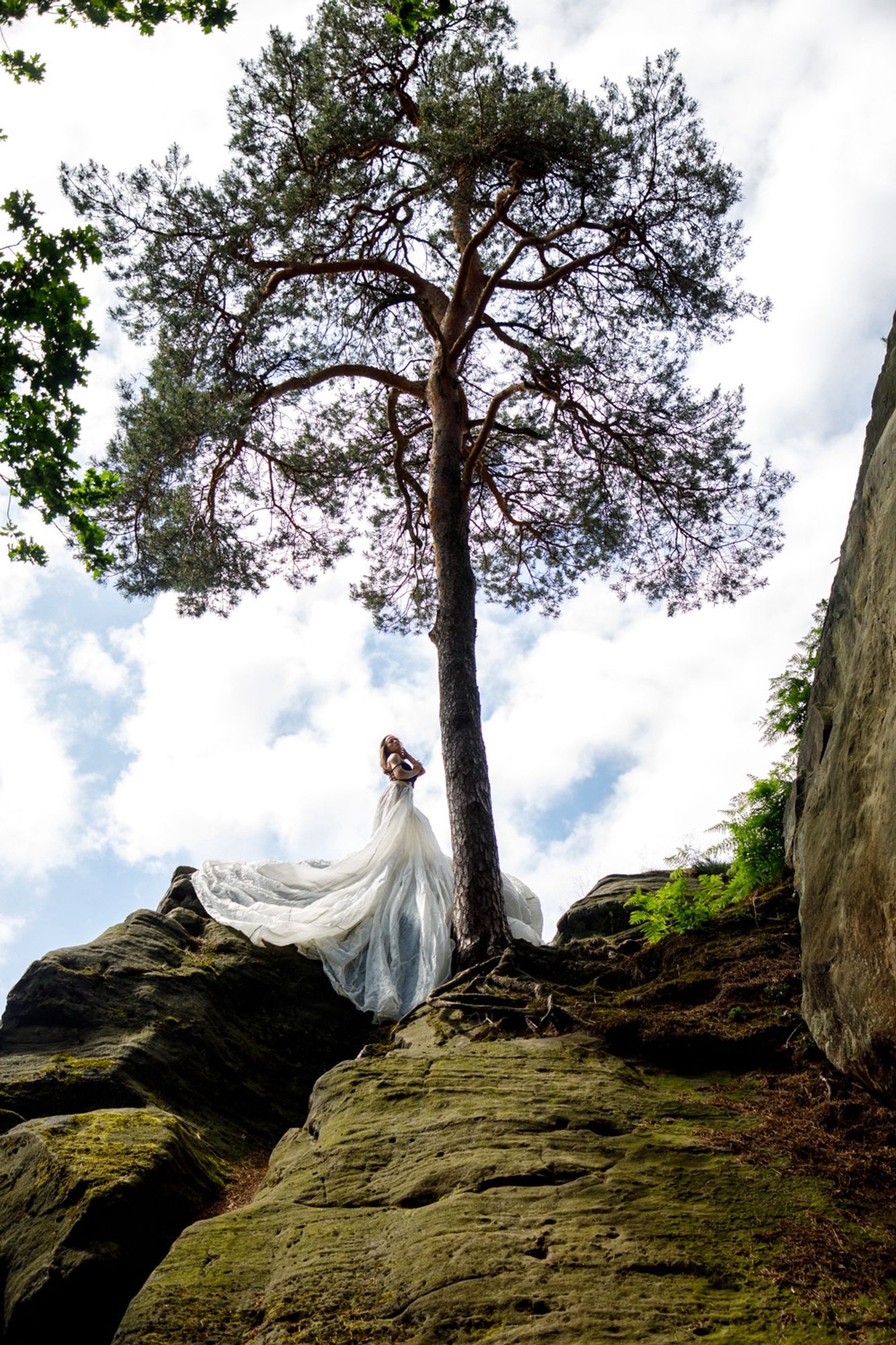 Eine Frau mit Fallschirm als Rock auf einem Felsen